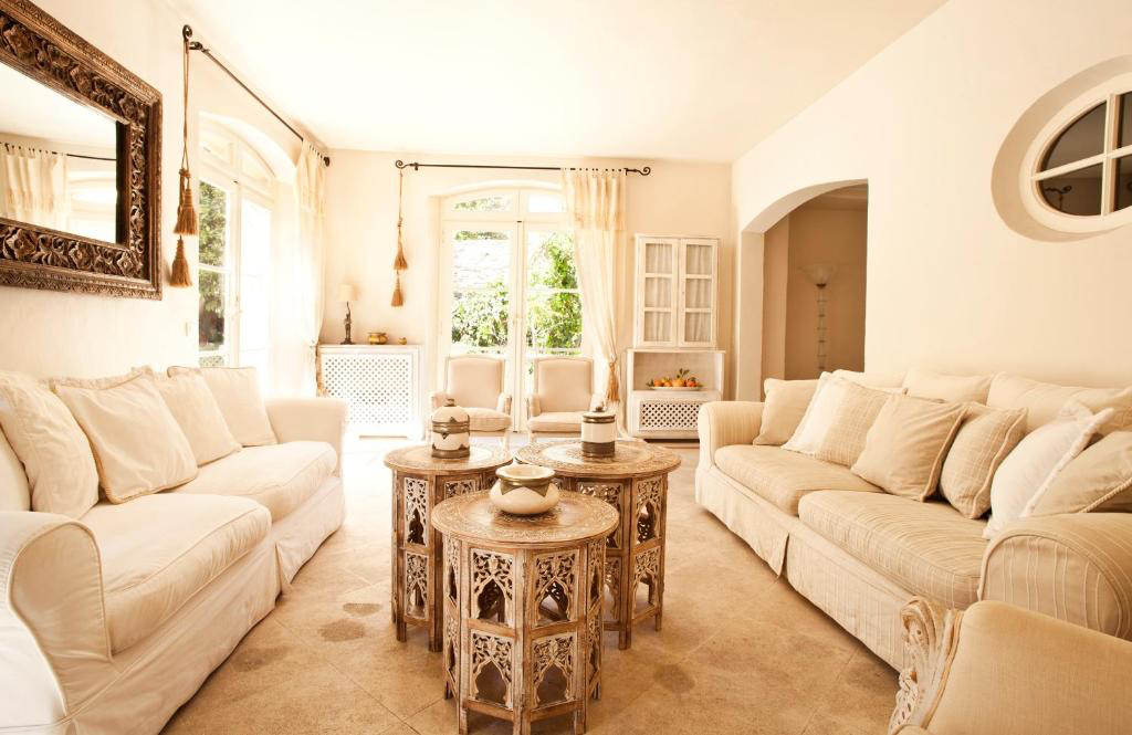 Helles Wohnzimmer mit hellen Sofas und orientalisch wirkenden Beistelltischen