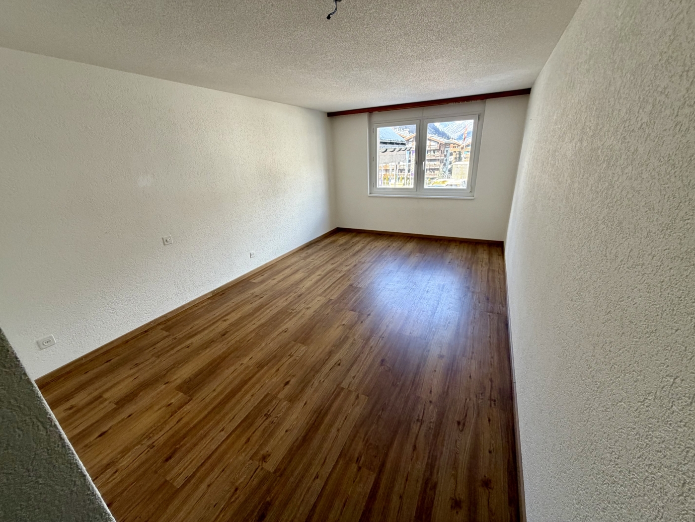 Leerer Raum mit Parkett und Fenster
