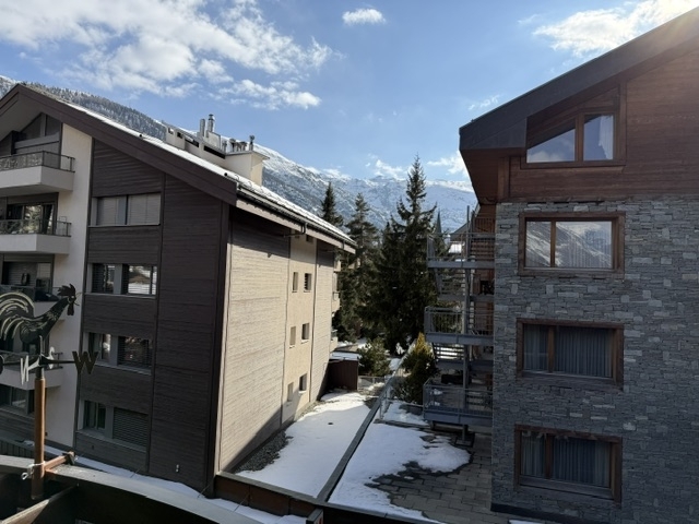 Außenansicht von alpinen Mehrfamilienhäusern mit Schneelandschaft