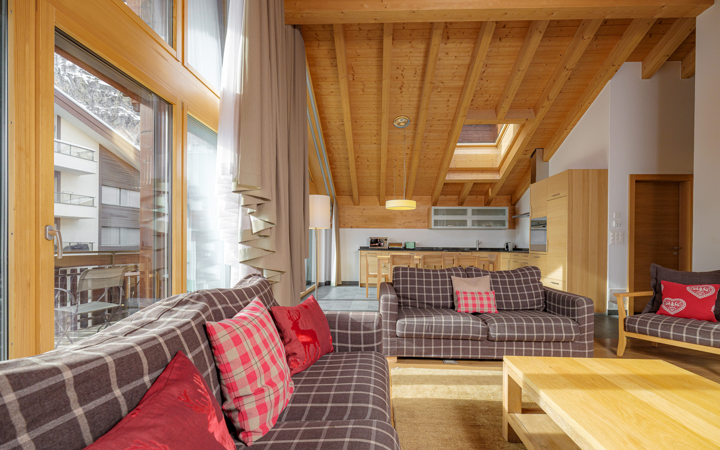 Heller Wohnraum mit offener Küche und Holzbalkendecke