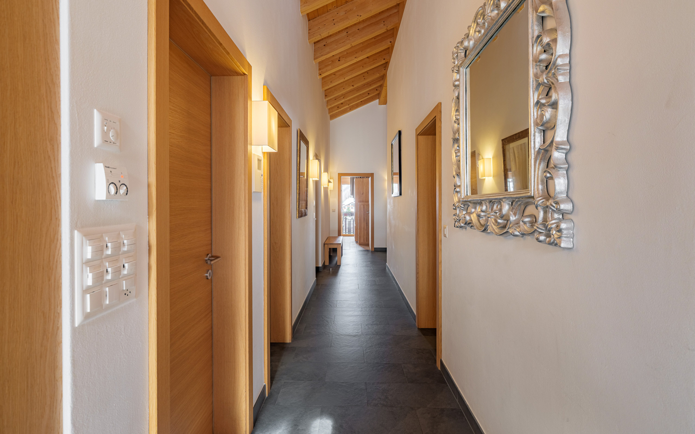 Langer Flur mit Holzdecke und dunklem Boden