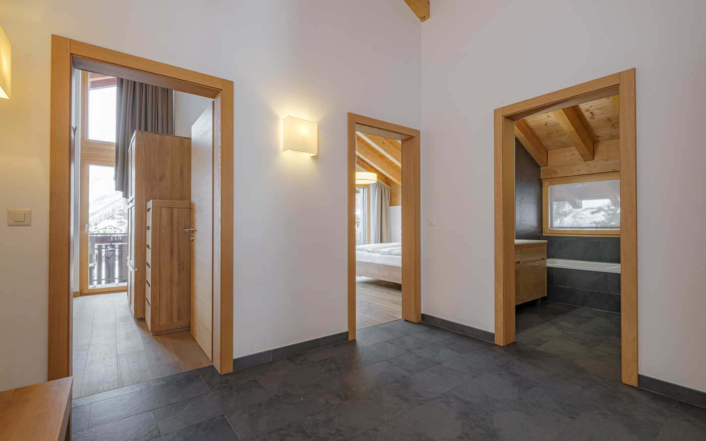 Flur mit drei Türen und Blick in Schlafzimmer und Bad