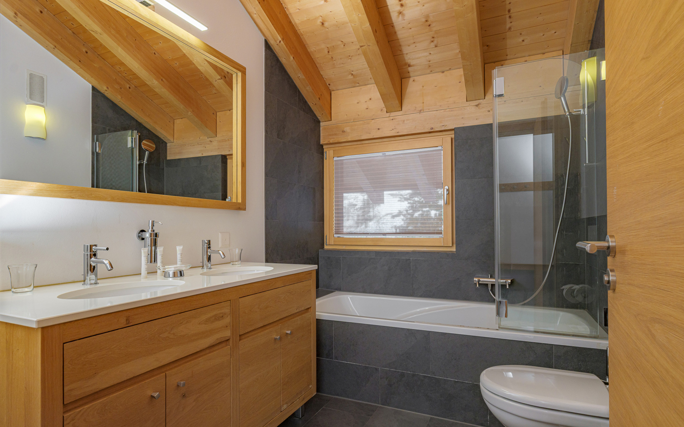 Modernes Badezimmer mit Holz und dunklen Fliesen