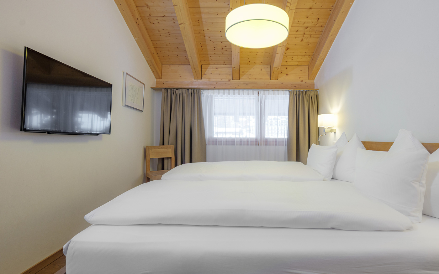 Helles Schlafzimmer mit Holzdecke und Doppelbett