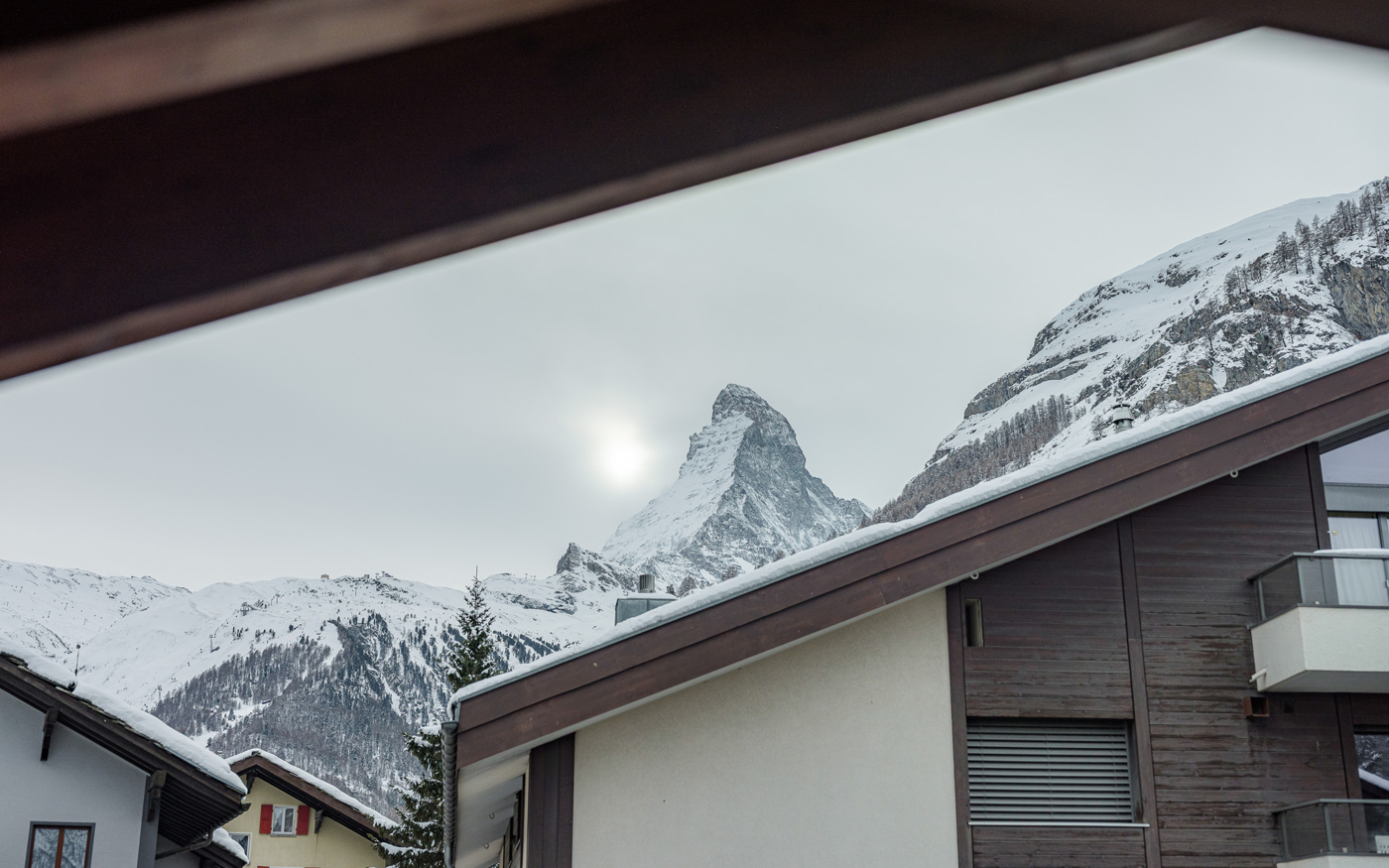 Blick auf verschneite Berge und Wohnhäuser