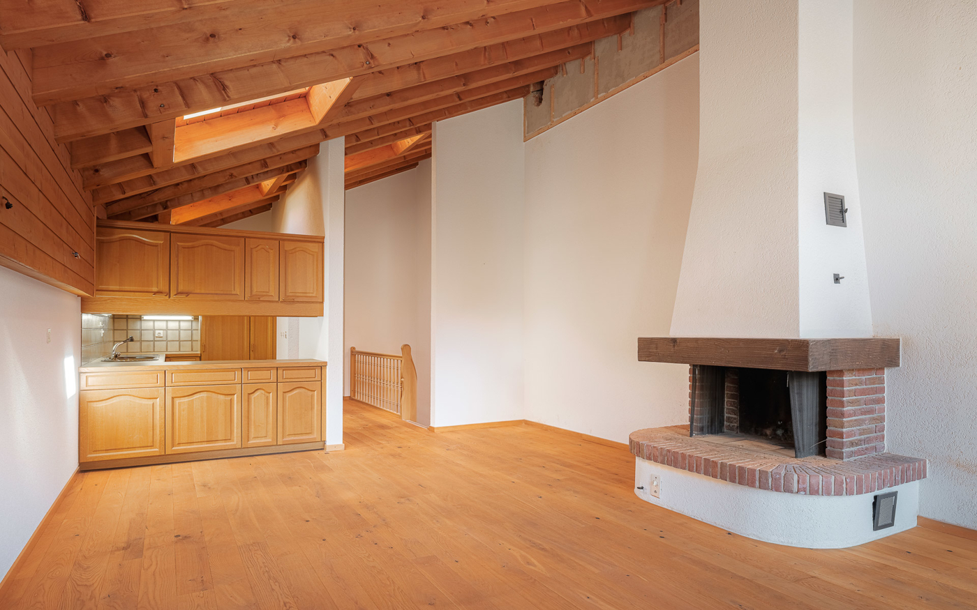 Dachgeschossraum mit Küche und Kamin