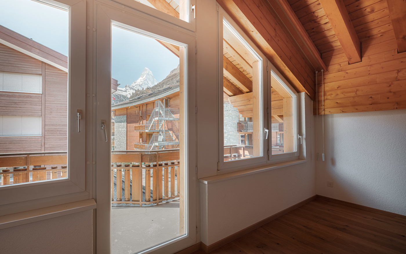 Heller Raum mit Balkon- bzw. Terrassentür und Bergblick