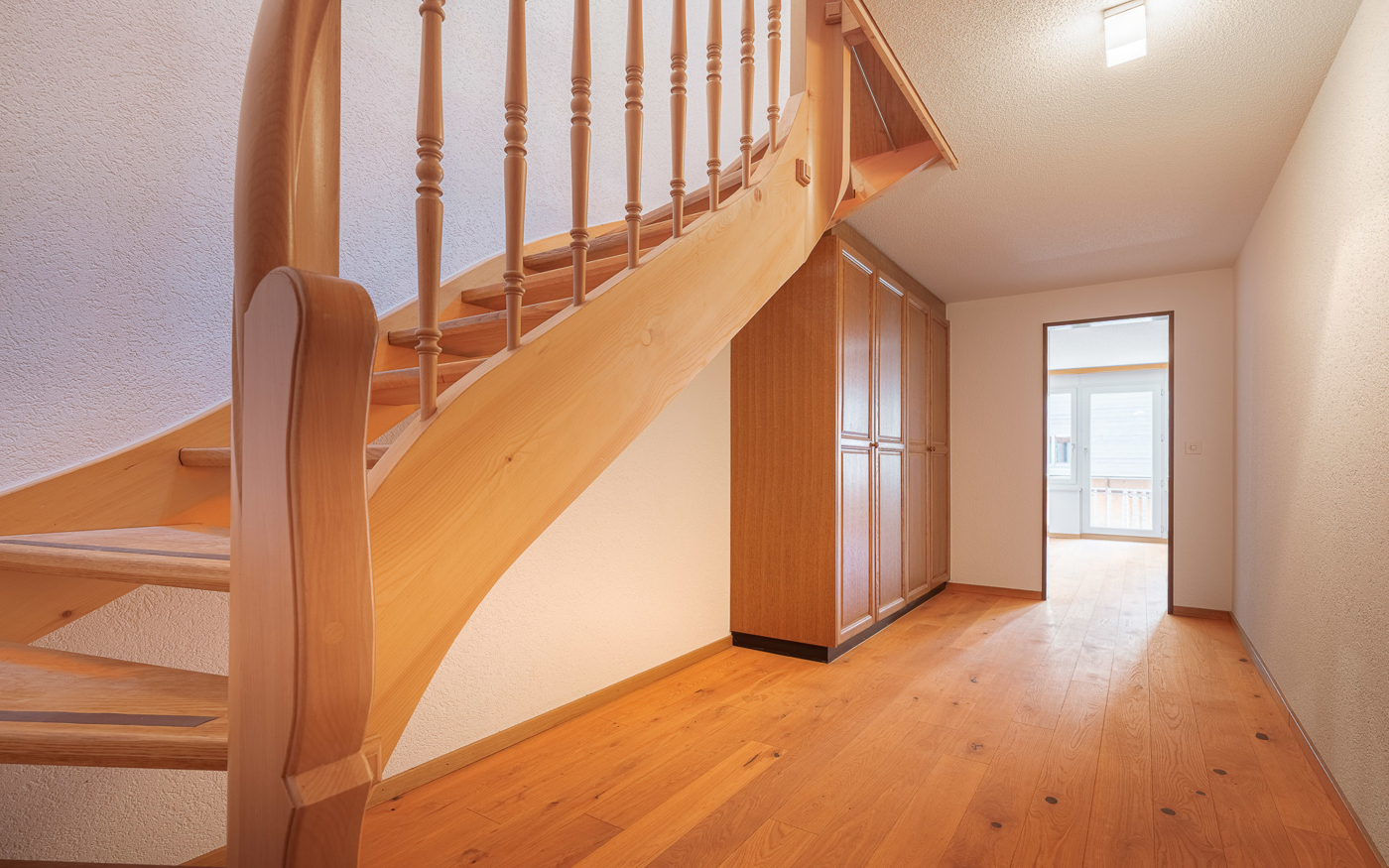 Heller Flur mit Holztreppe und Einbauschrank