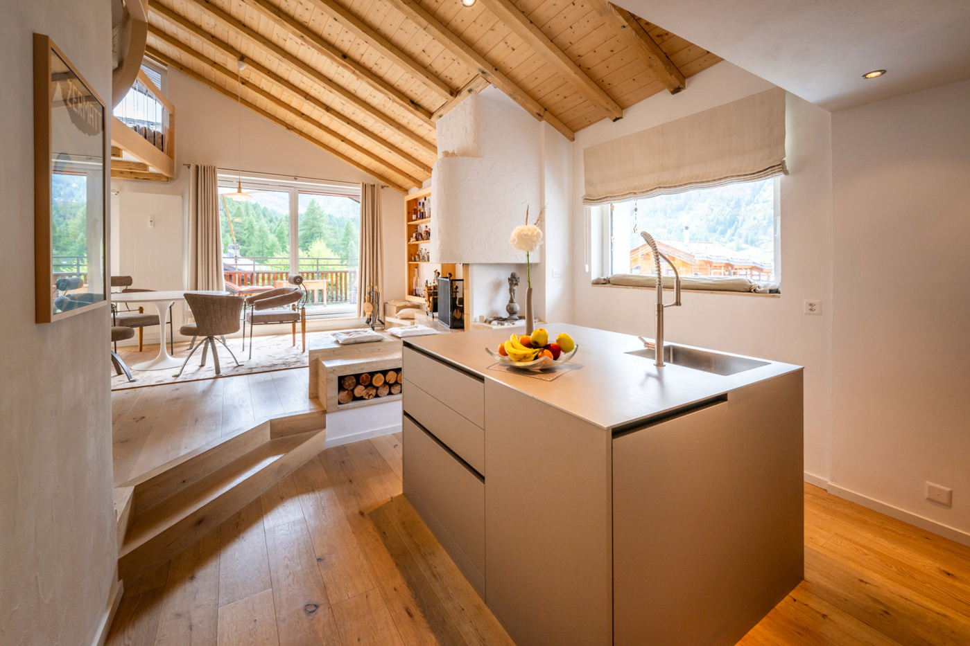Helle Wohnküche mit offenem Wohnbereich und Kamin