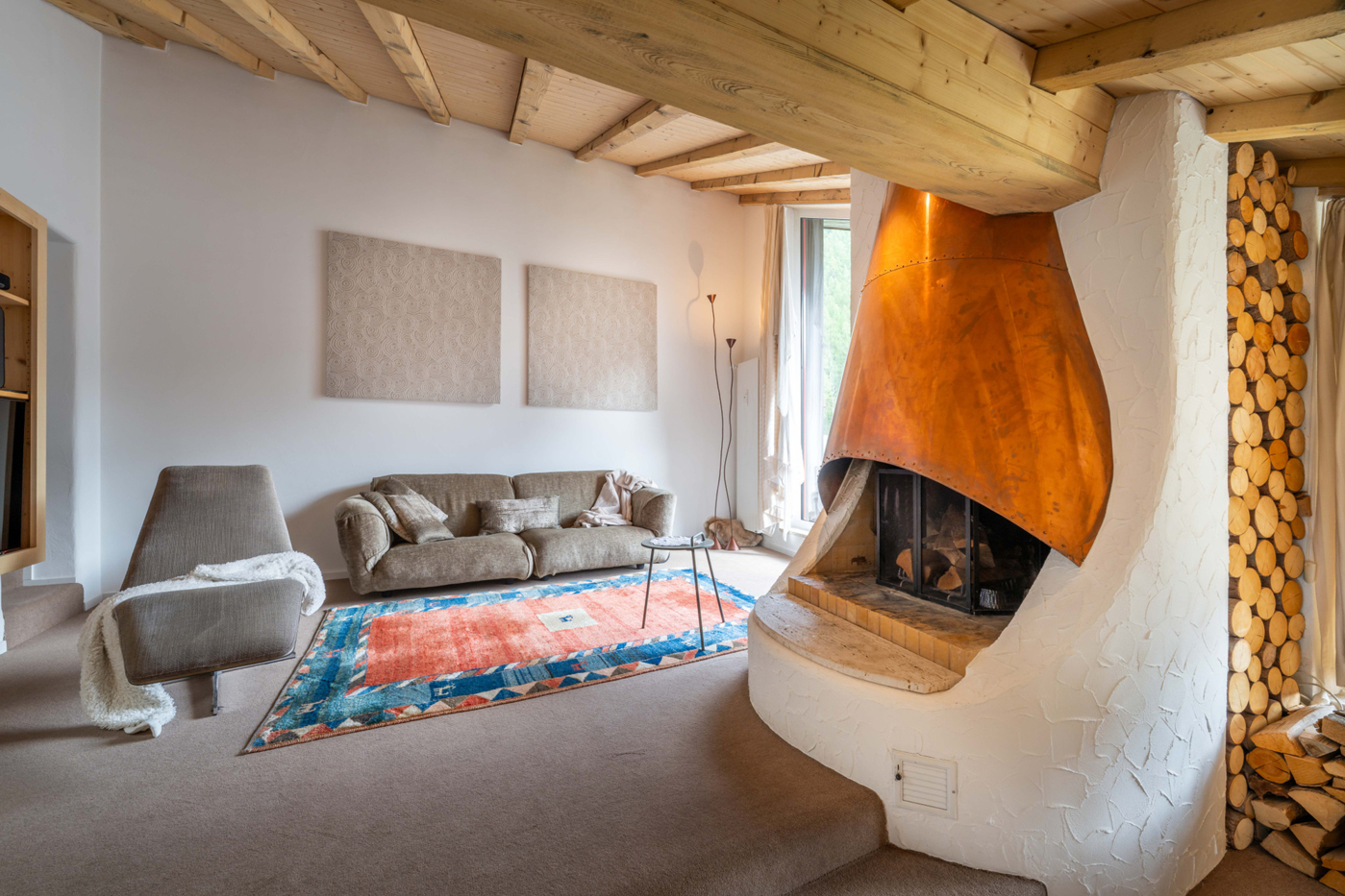Wohnzimmer mit Kamin und Holzbalkendecke