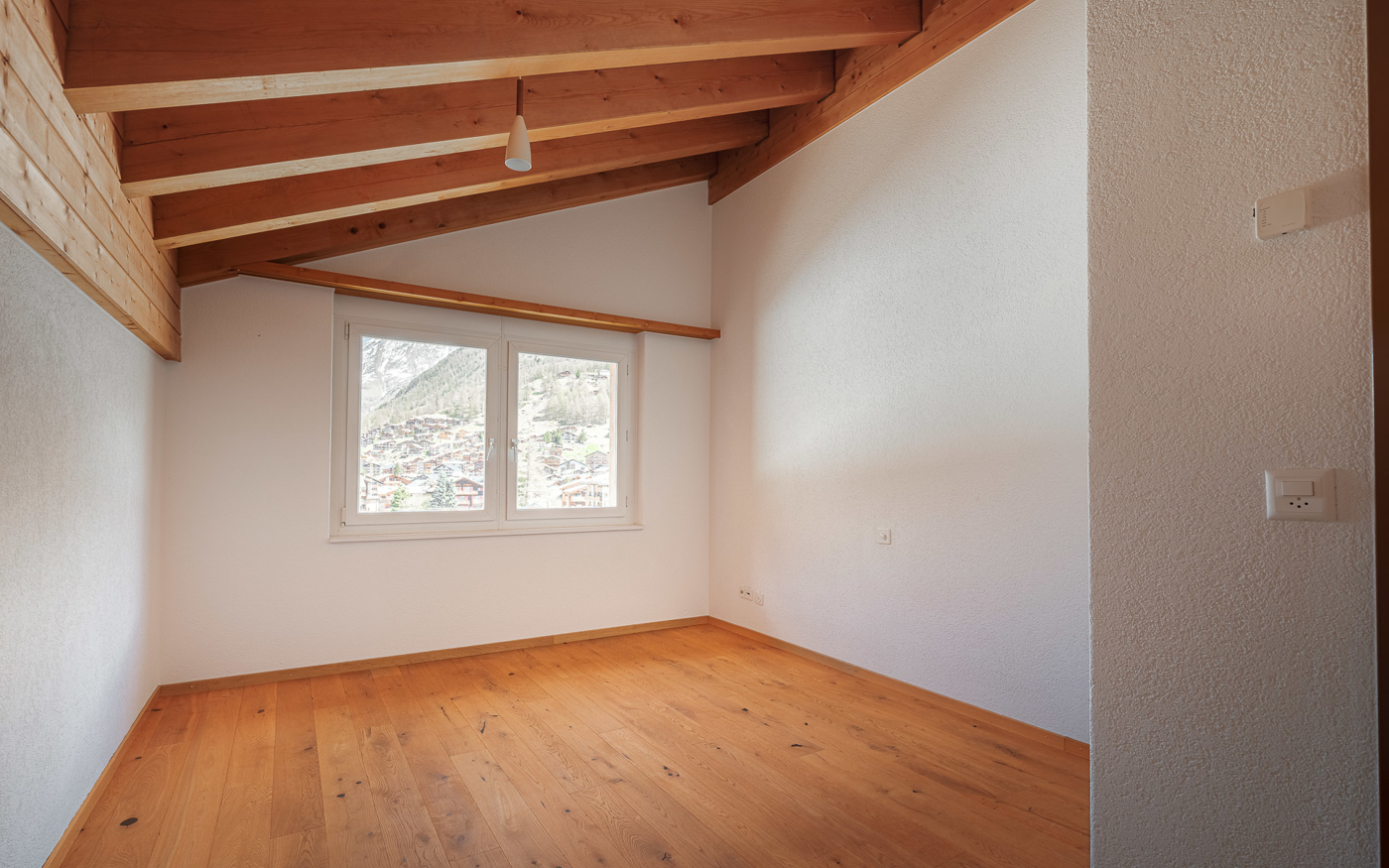 Leerer Raum mit Holzbalkendecke und Bergblick