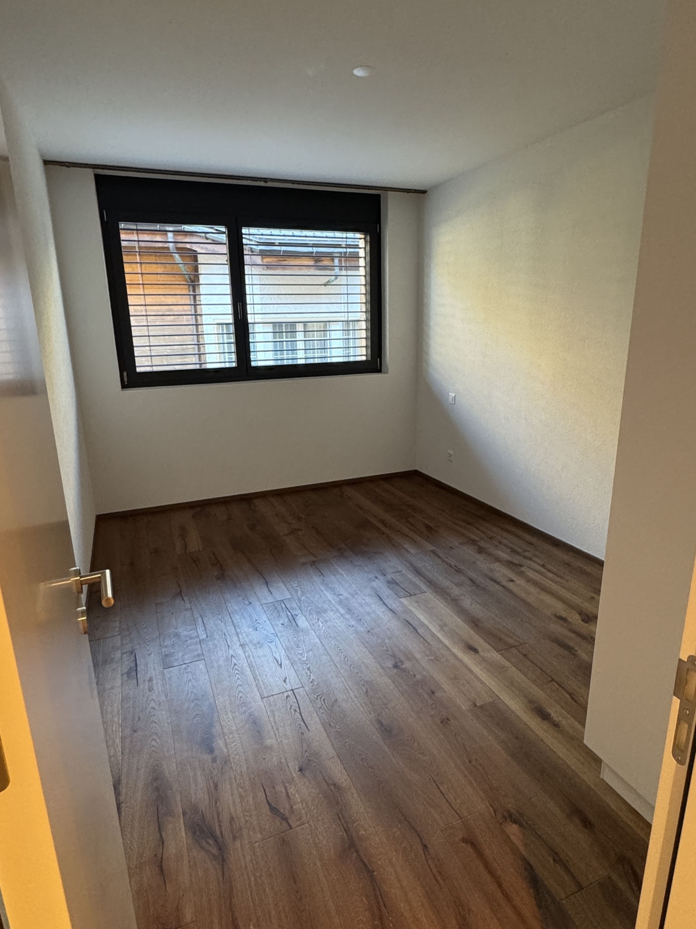 Leerer Raum mit Holzboden und Fenster