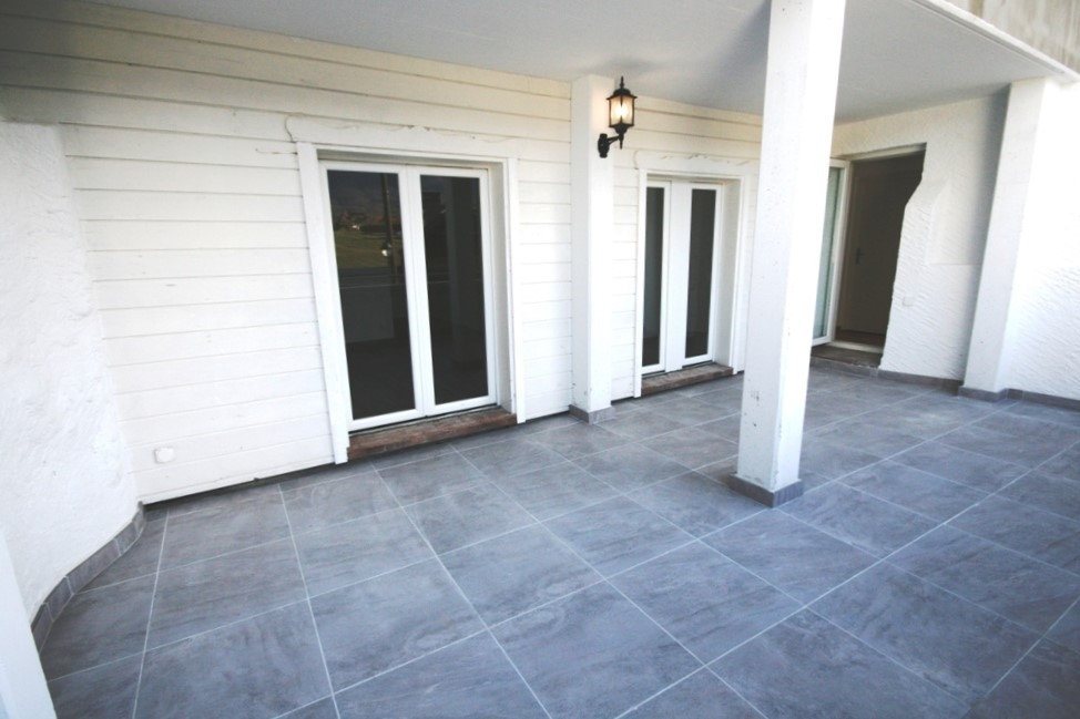 Überdachte Terrasse mit Fliesenboden