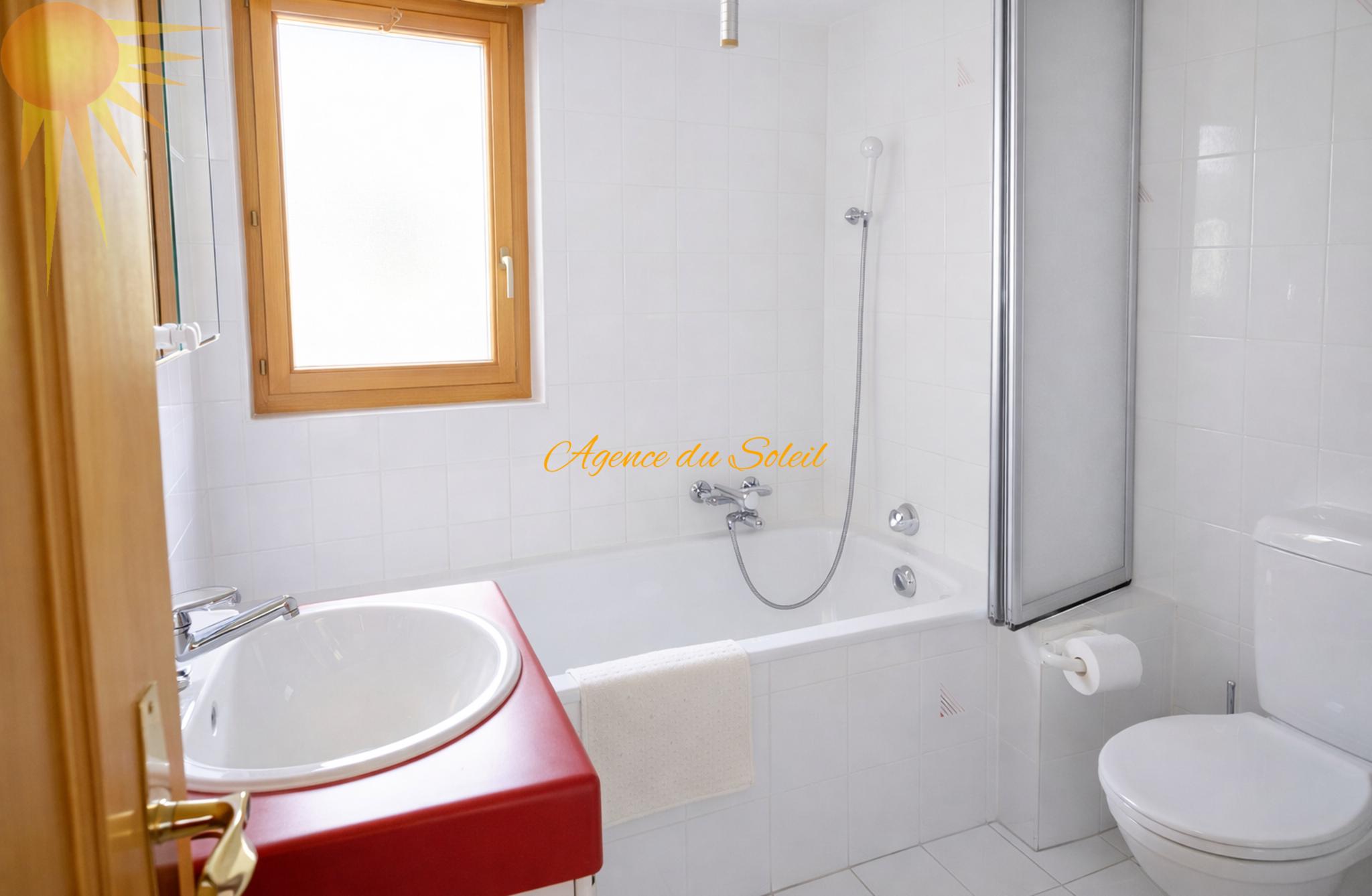 Helles Badezimmer mit Badewanne und Fenster