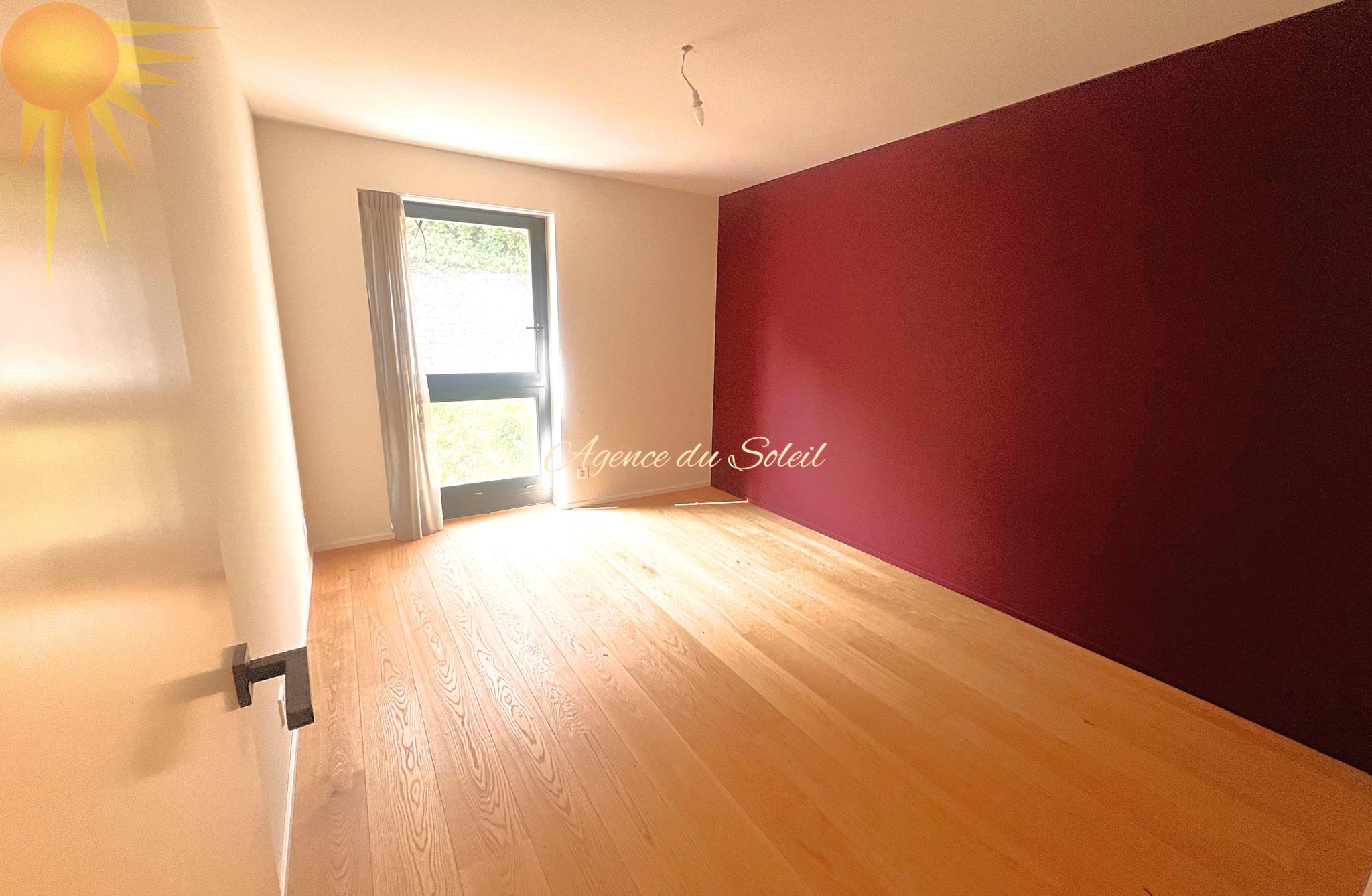 Leerer Raum mit Fenster und roter Akzentwand