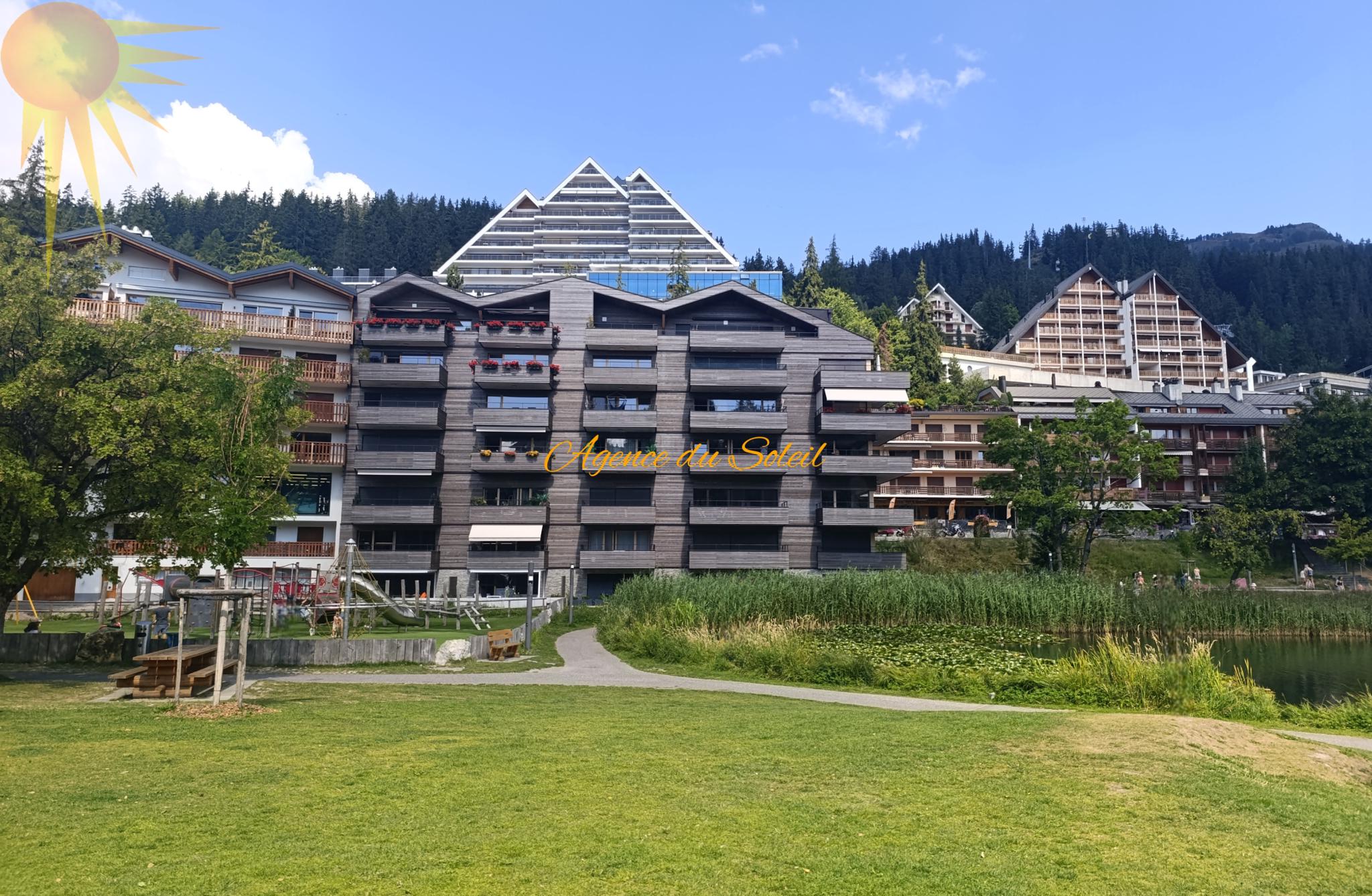 Außenansicht einer alpinen Wohnanlage am Wasser