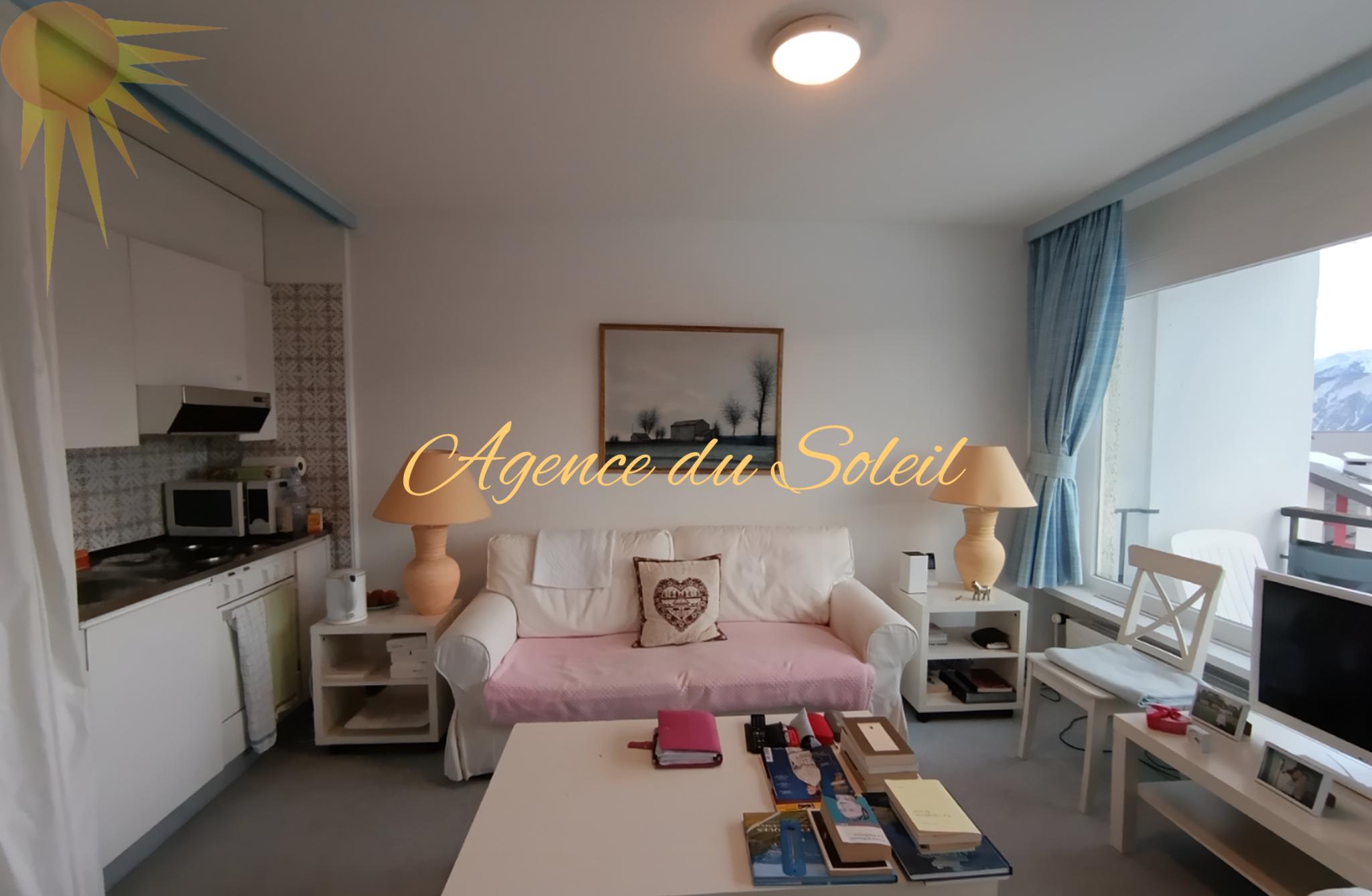 Wohnzimmer mit Küchenzeile und Balkonblick