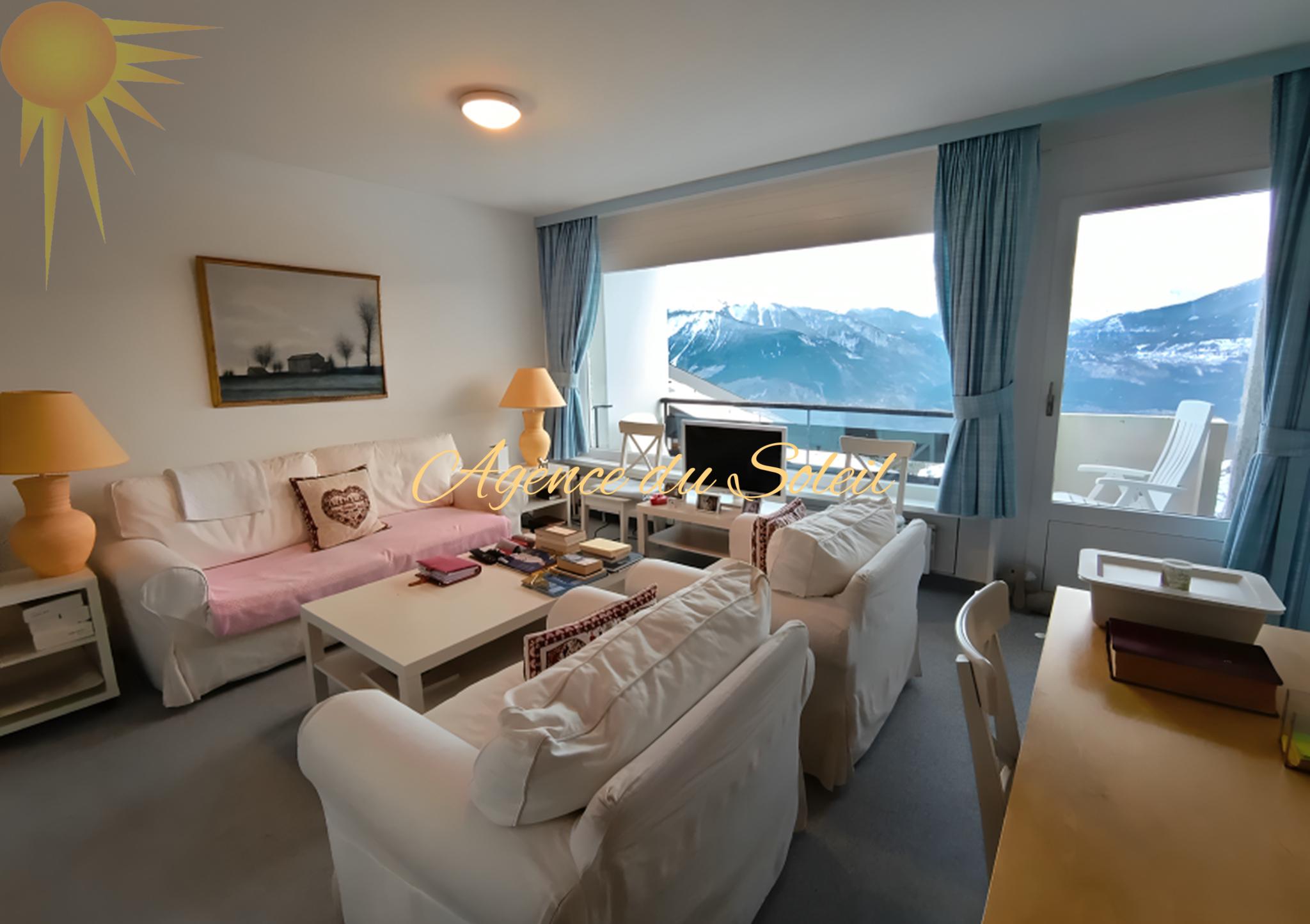Hell eingerichtetes Wohnzimmer mit Bergblick