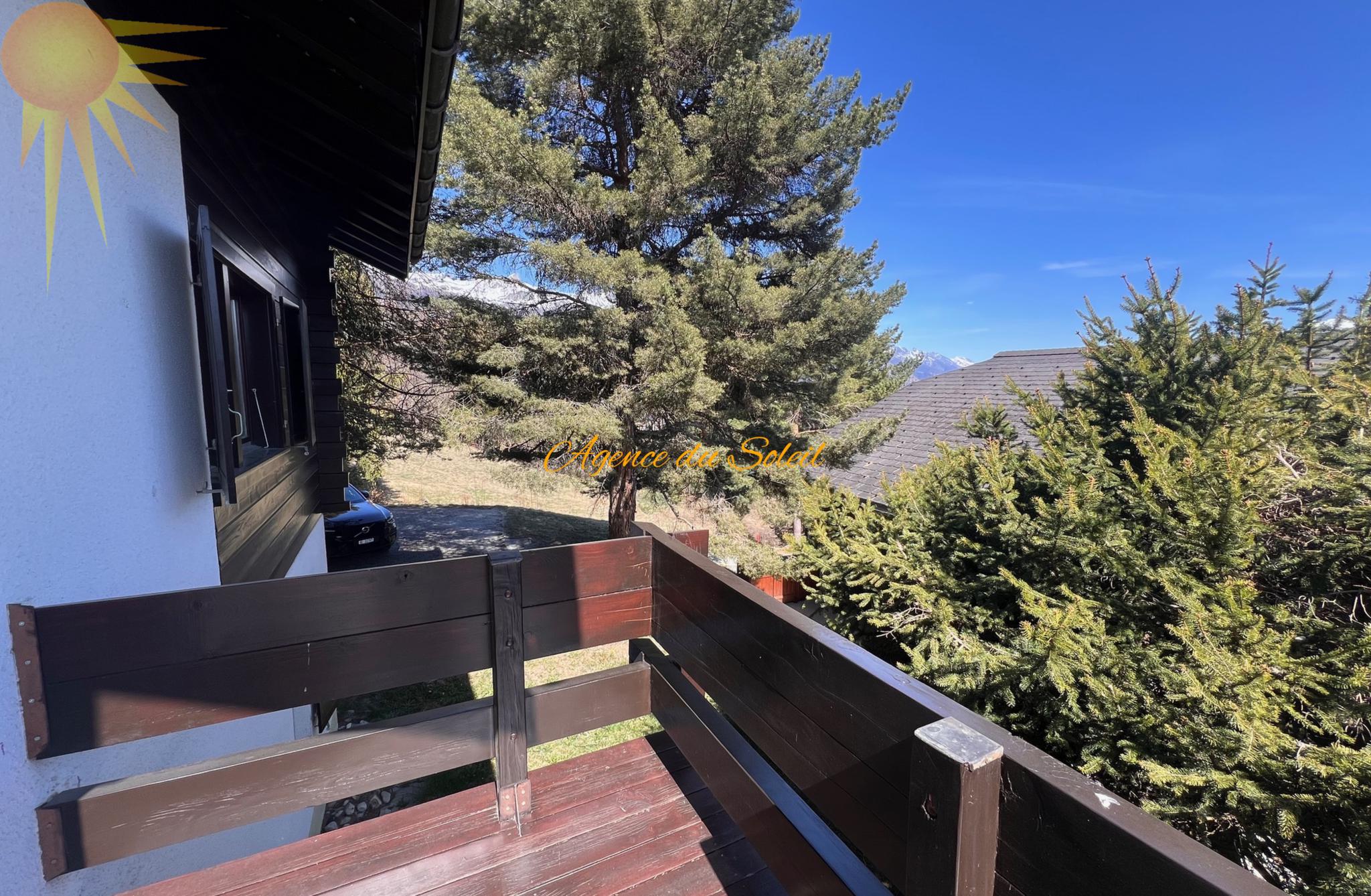 Balkon mit Berg- und Baumblick