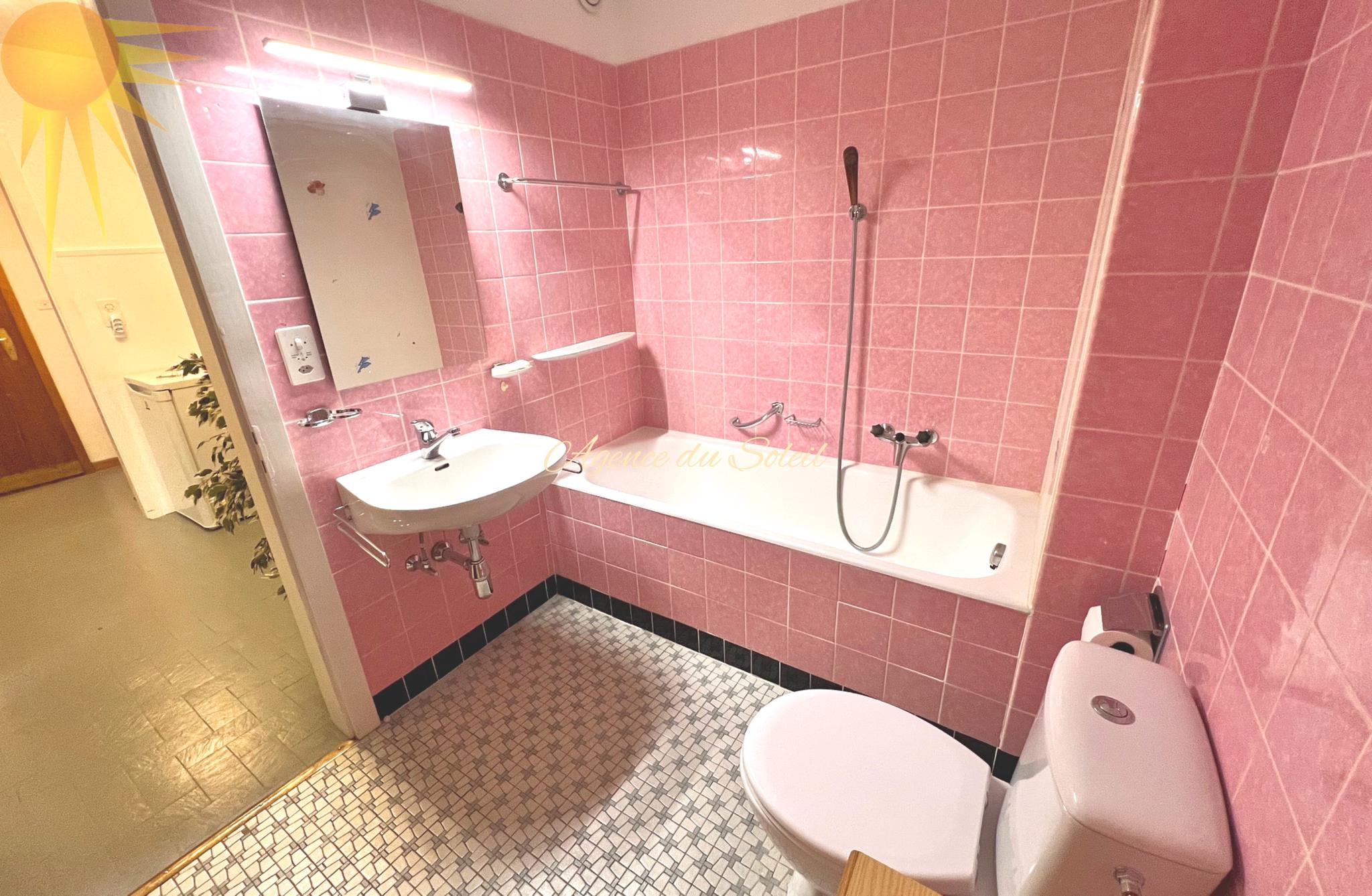 Rosa Badezimmer mit Badewanne und WC