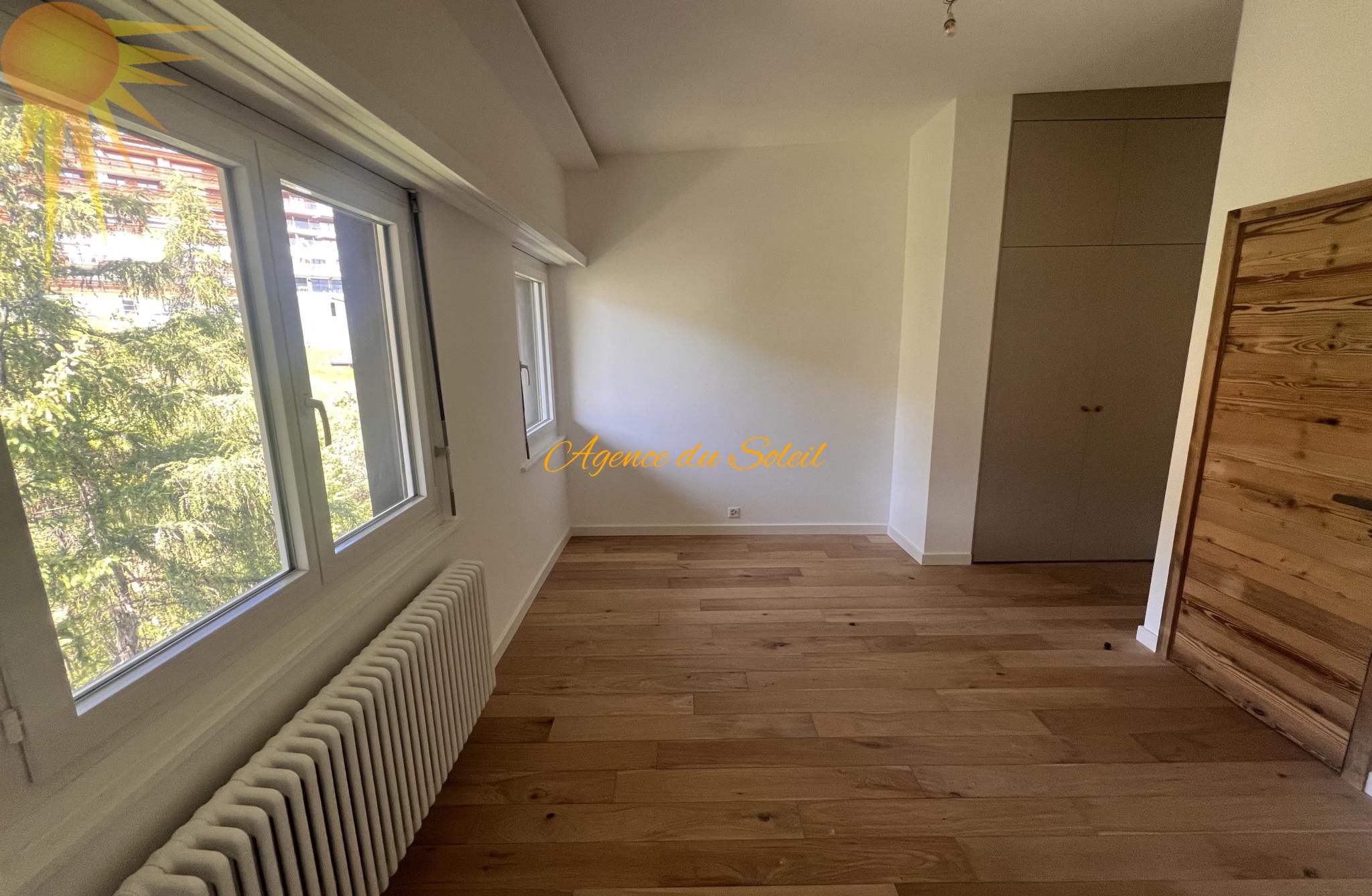 Helles, leer stehendes Zimmer mit Parkett und Einbauschrank