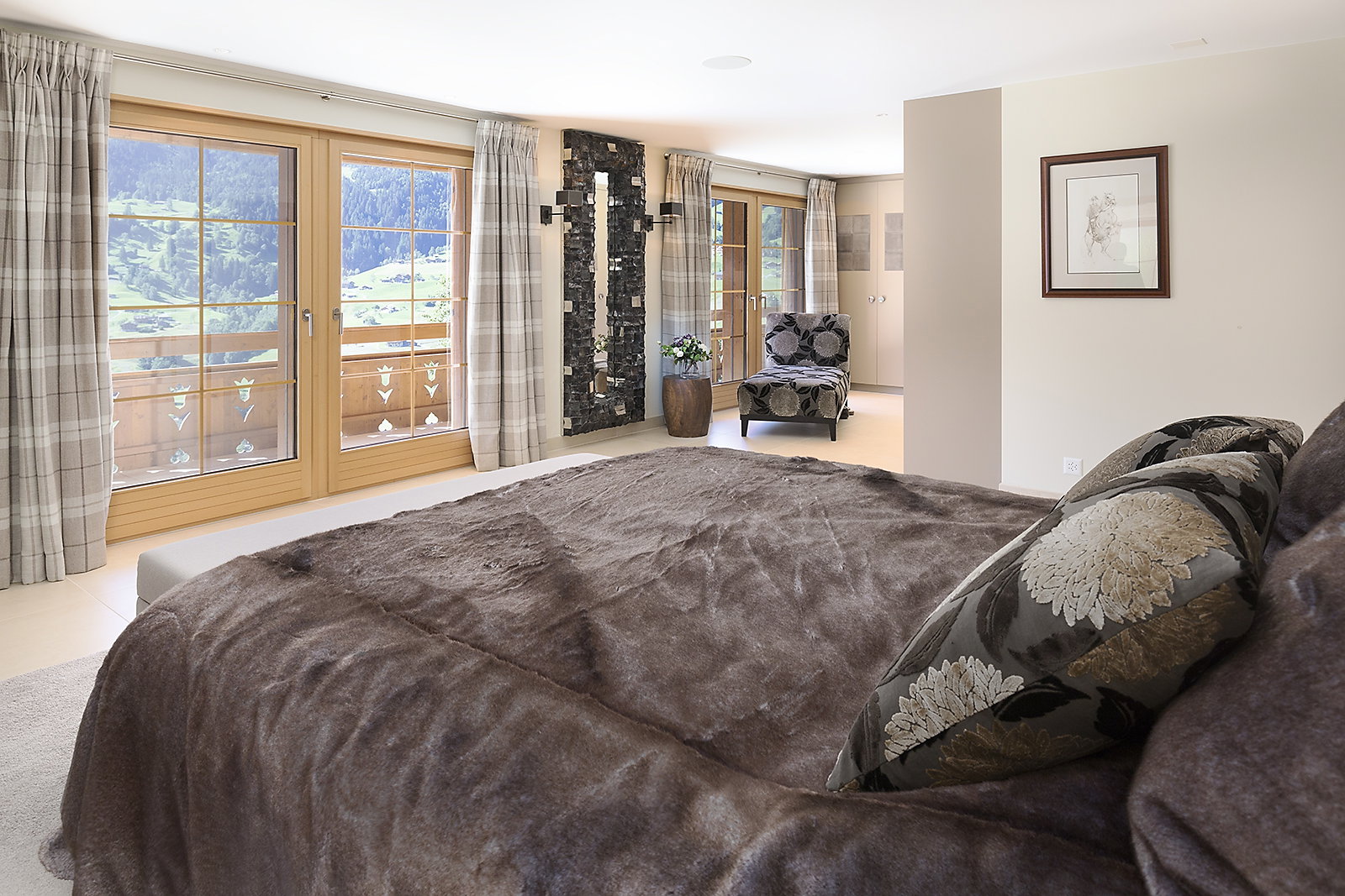 Helles Schlafzimmer mit Panoramafenstern und Bergblick
