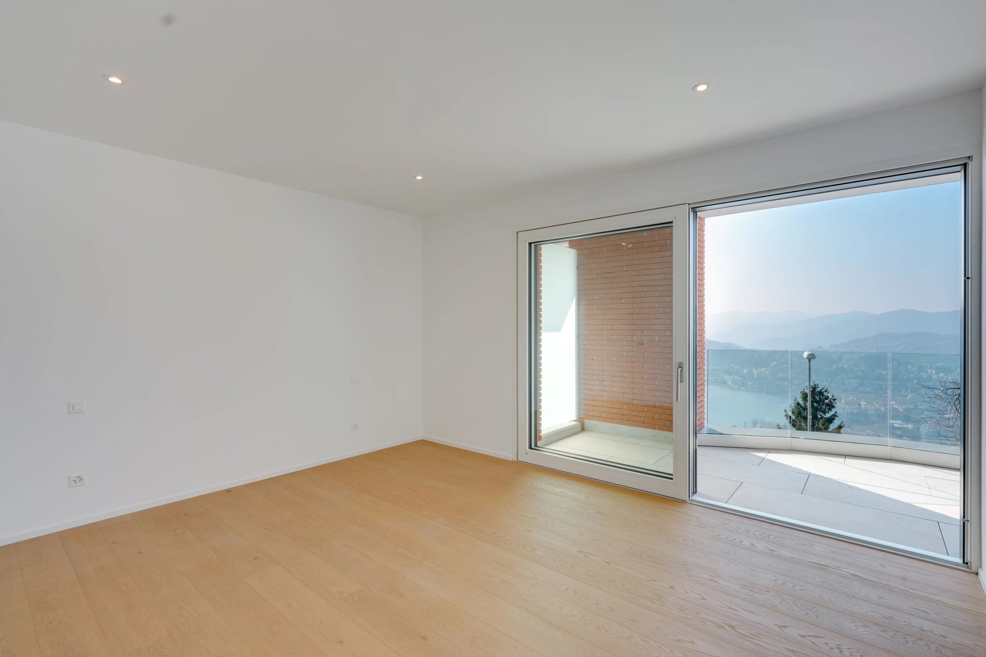 Heller leerer Wohnraum mit Balkon und Ausblick
