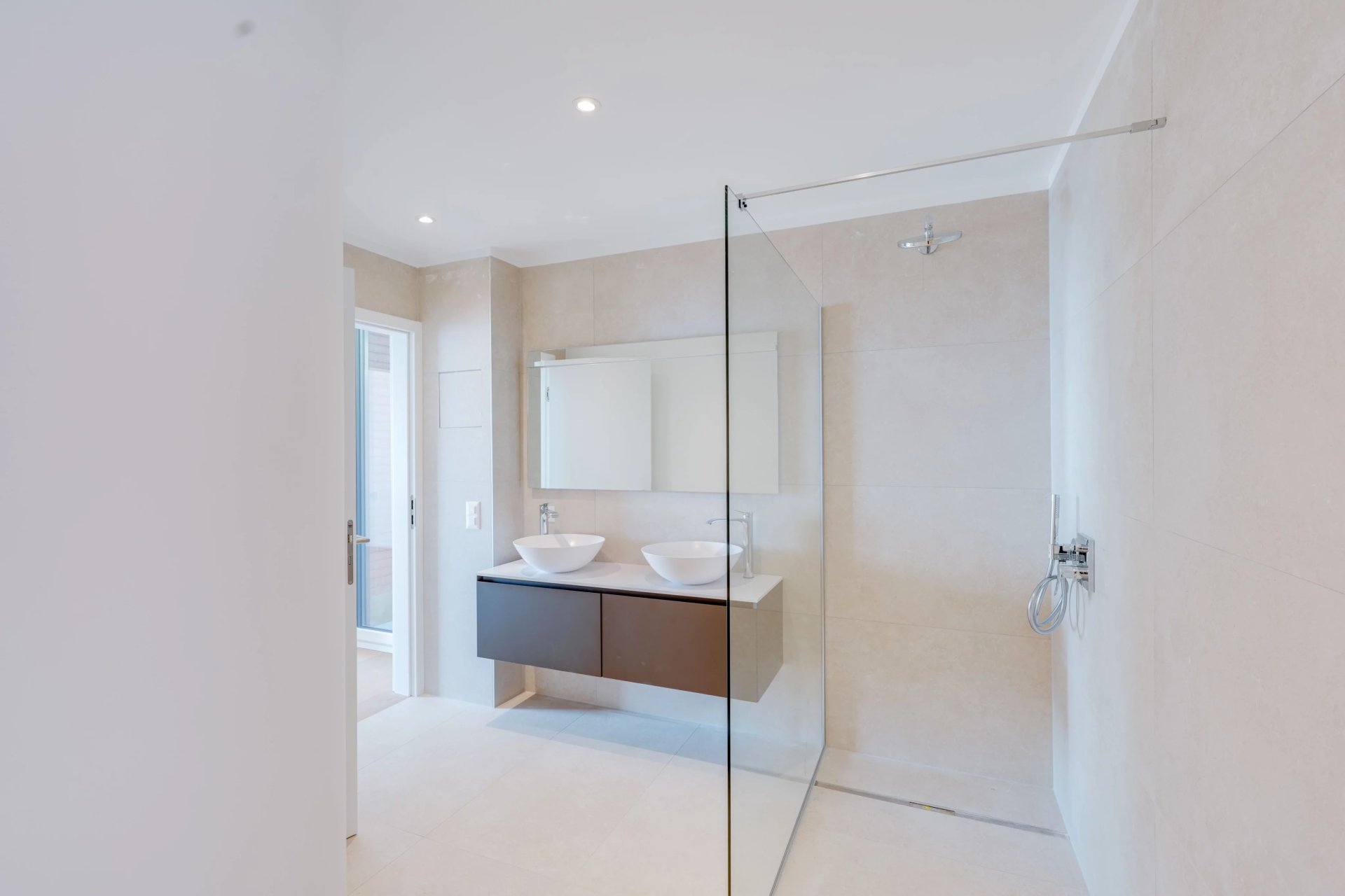 Helles, modernes Badezimmer mit Doppelwaschbecken und begehbarer Dusche