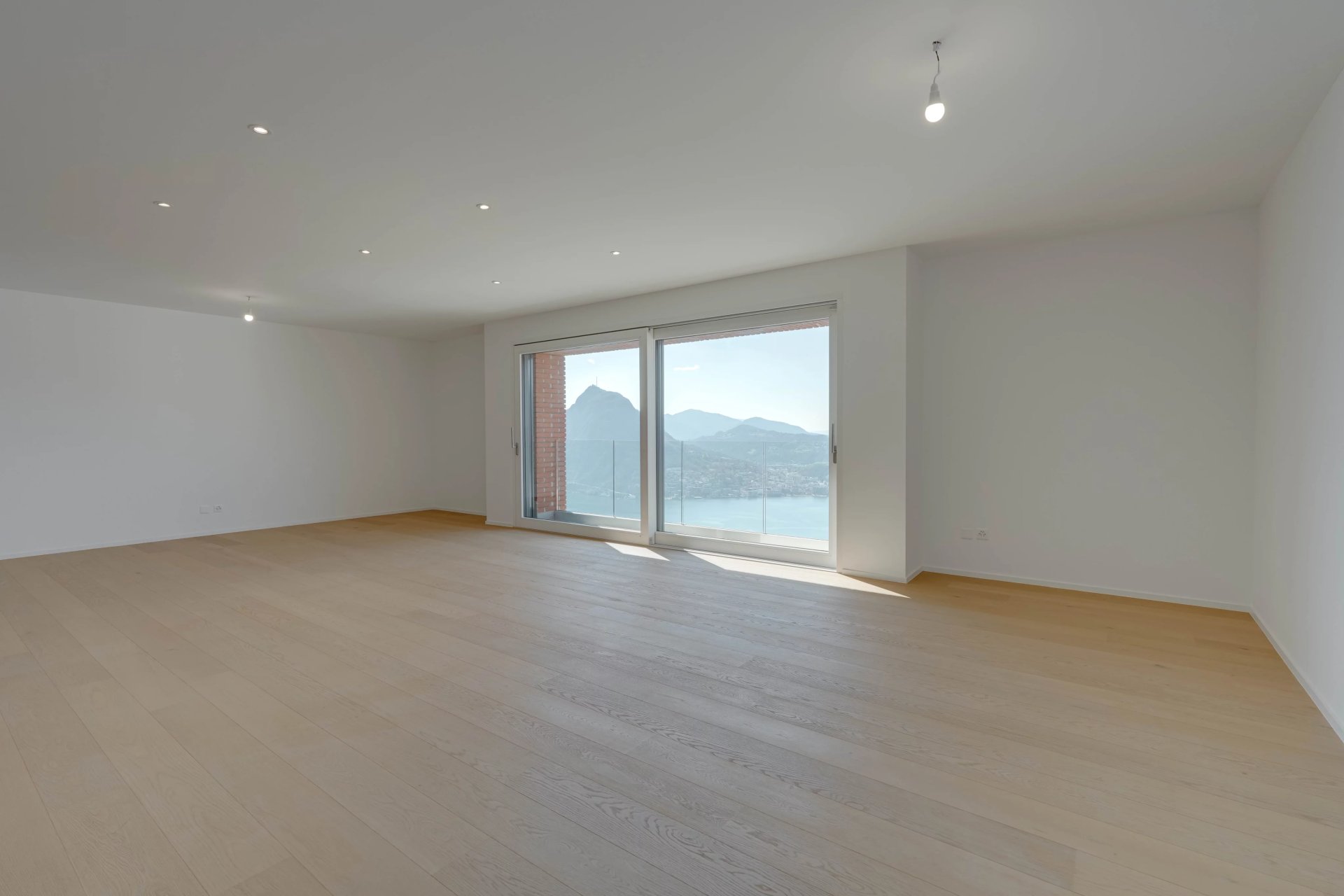 Heller, leerer Wohnraum mit Meer- und Bergblick