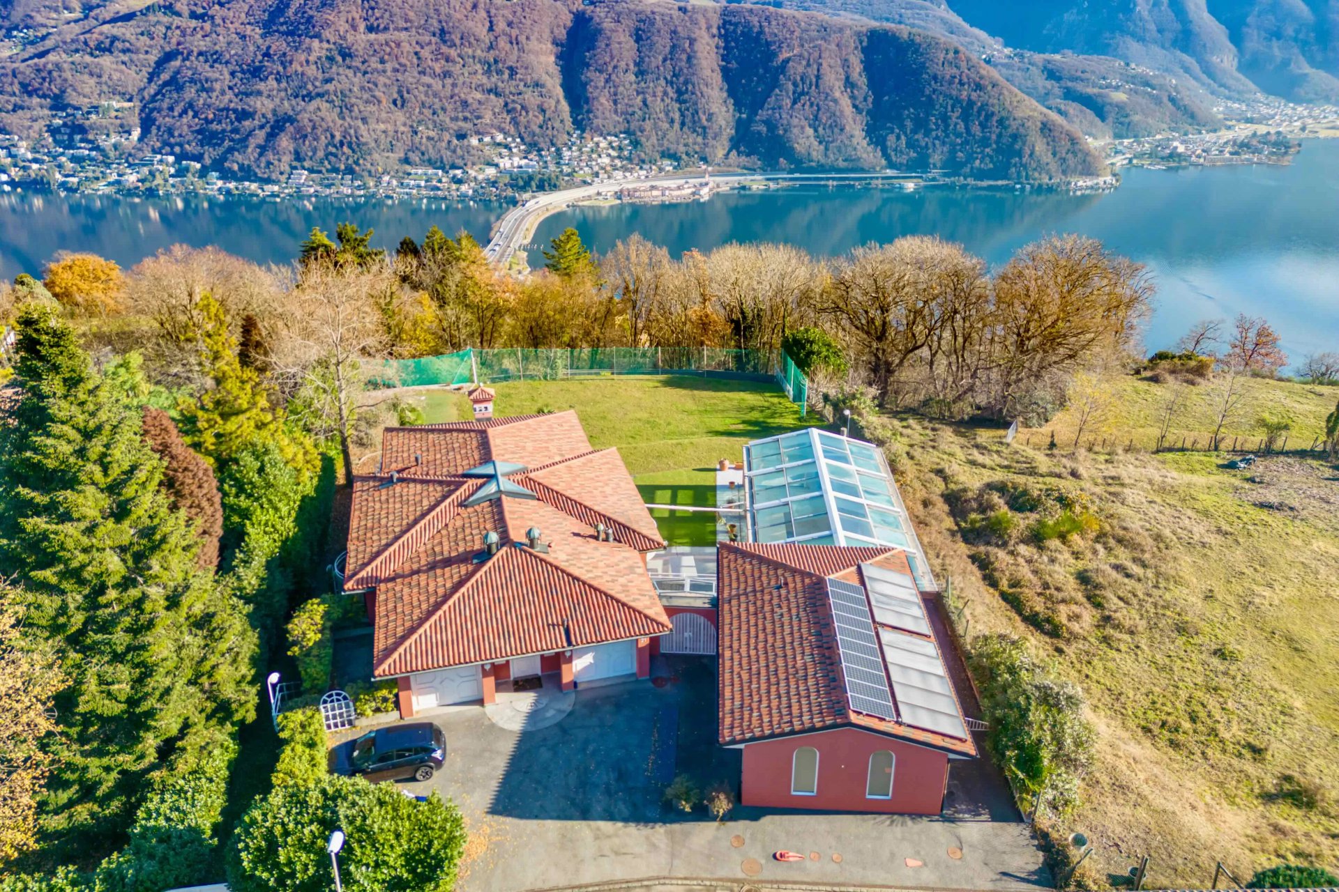 Luftaufnahme eines Seeblick-Anwesens mit Terrakotta-Dächern