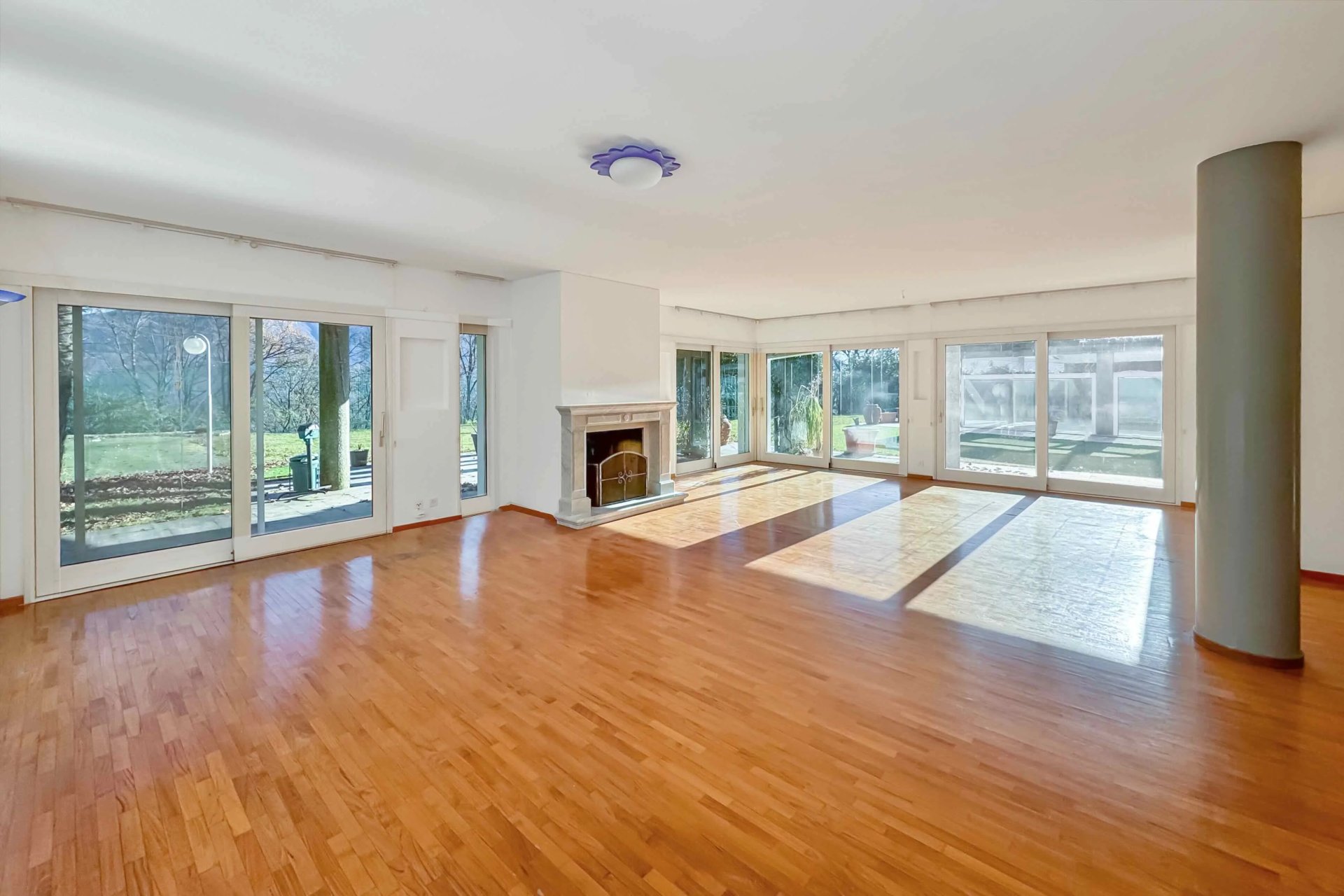 Großer Wohnraum mit Kamin und Panoramafenstern