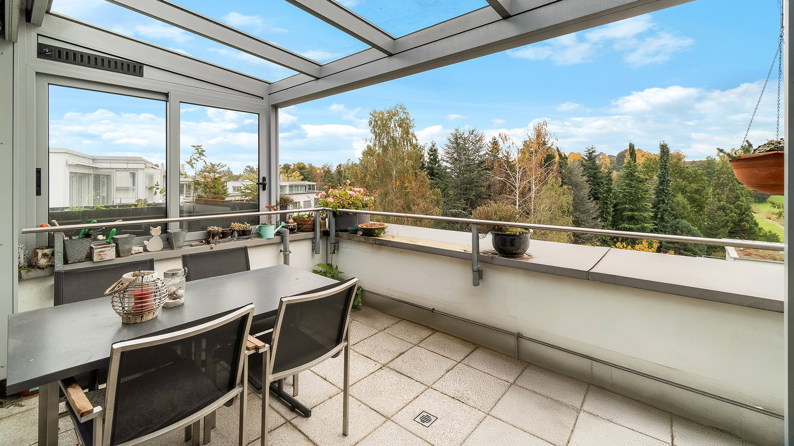 Überdachter Balkon mit Sitzgruppe und Grünblick