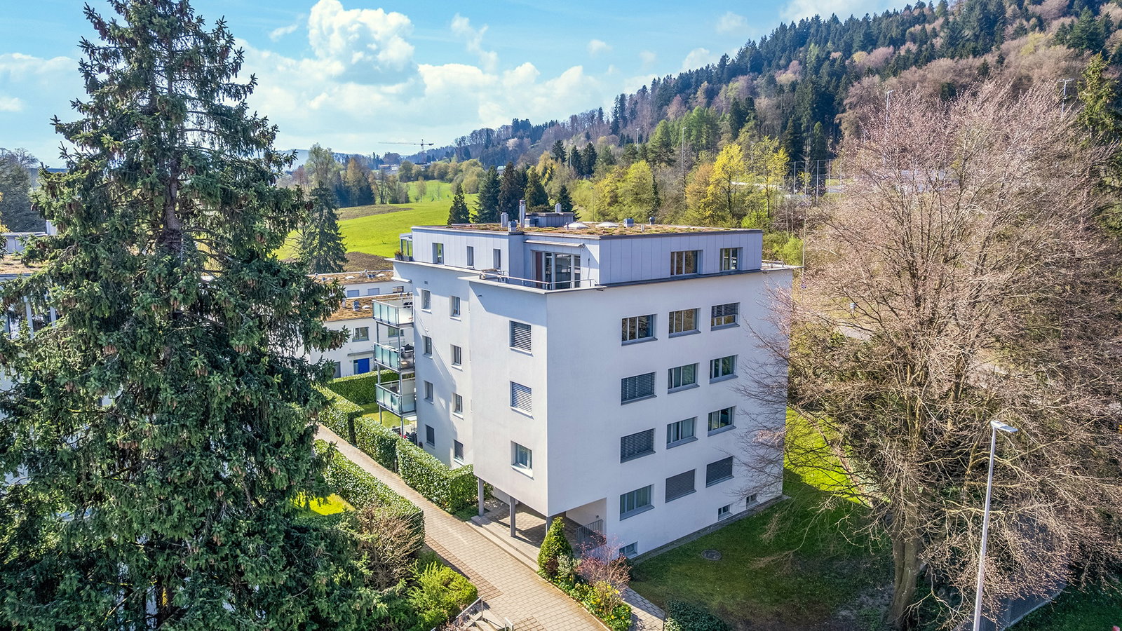 Außenansicht eines modernen Mehrfamilienhauses in grüner Hanglage