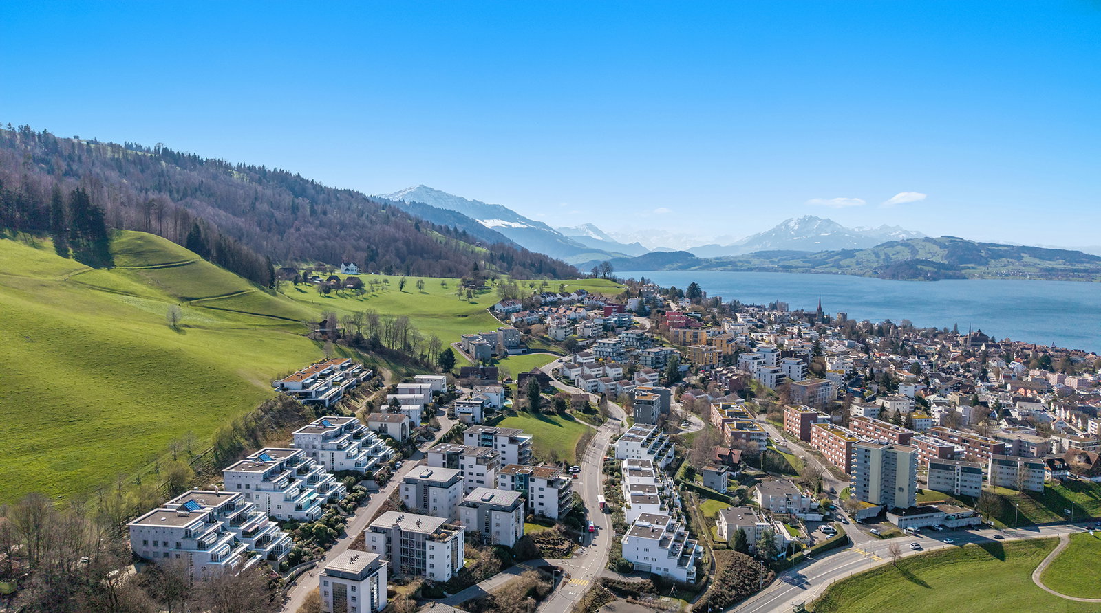 Luftaufnahme einer Stadt am See mit Bergen