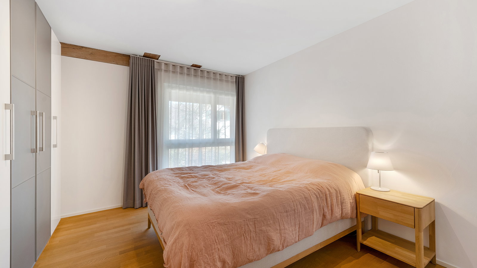 Helles Schlafzimmer mit Doppelbett und Kleiderschrank