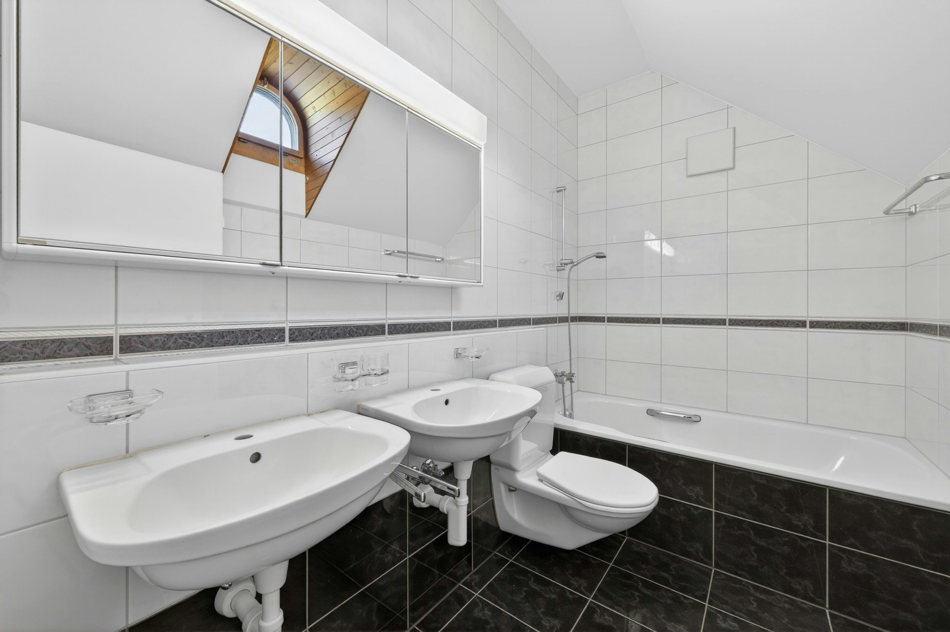 Badezimmer mit Badewanne und Doppelwaschbecken