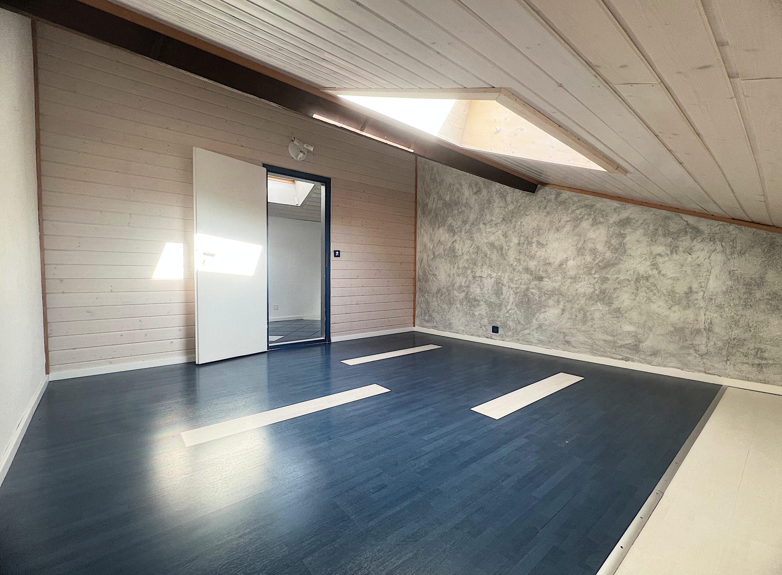 Dachgeschossraum mit Dachfenster und markanter Wandgestaltung