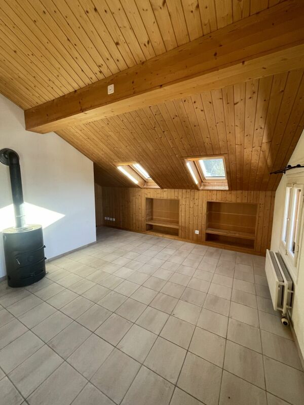 Dachzimmer mit Holzverkleidung und Holzofen