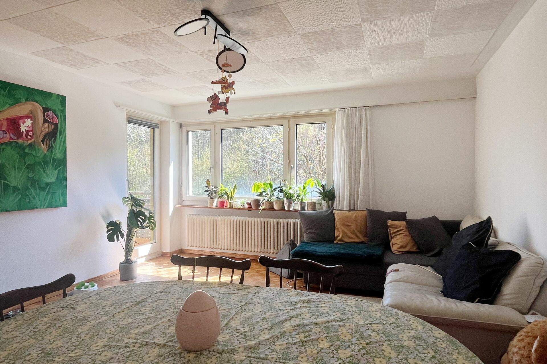 Helles Wohnzimmer mit großem Fenster und Sitzgruppe