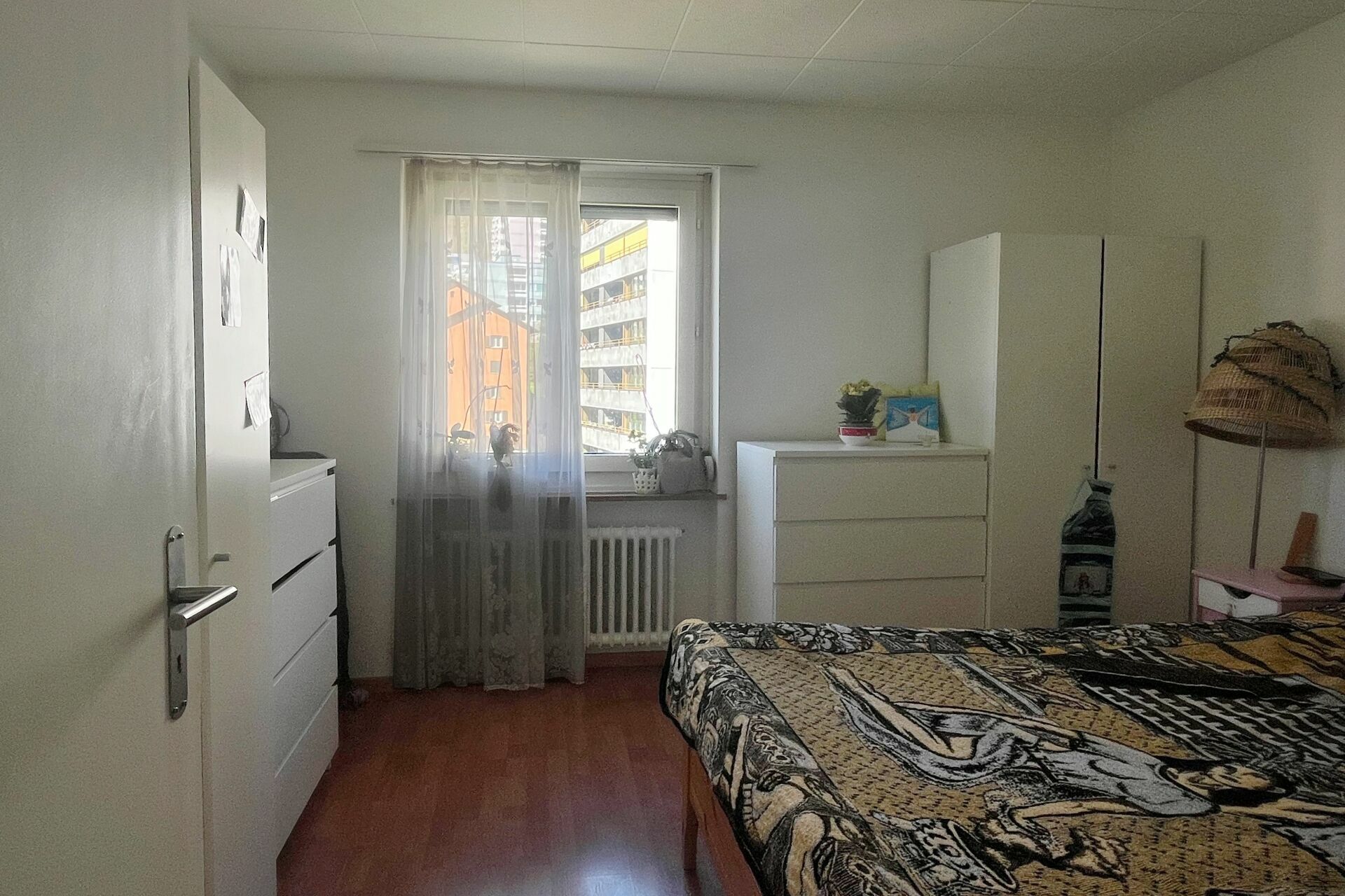 Schlafzimmer mit Fenster und weißem Mobiliar