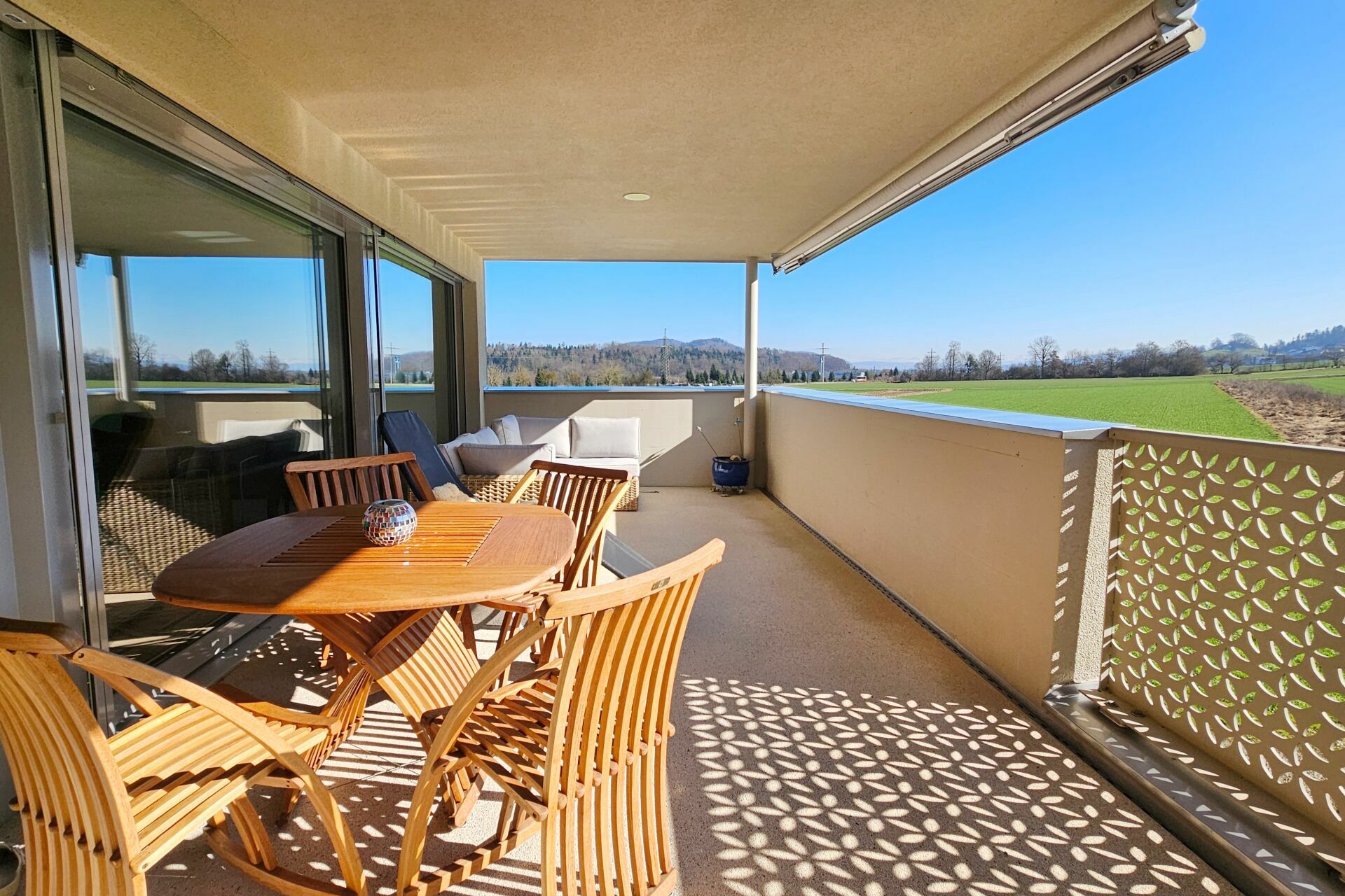 Überdachter Balkon mit Sitzgruppe und weitem Landschaftsblick
