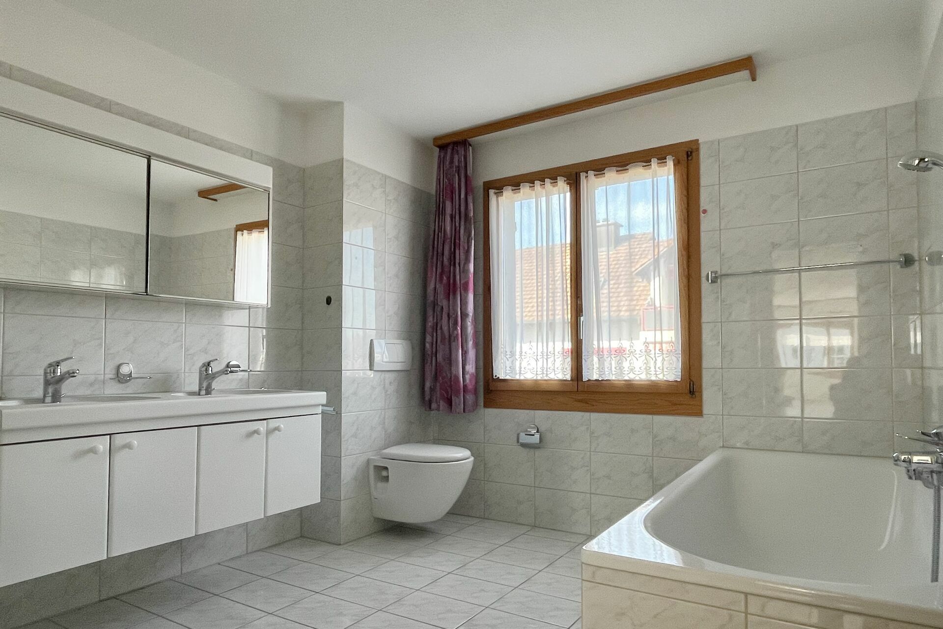 Helles Badezimmer mit Badewanne und Fenster