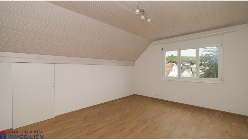 Helles Dachgeschosszimmer mit Fensterblick