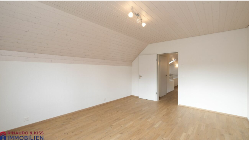 Heller Dachraum mit Holzdecke und Parkettboden
