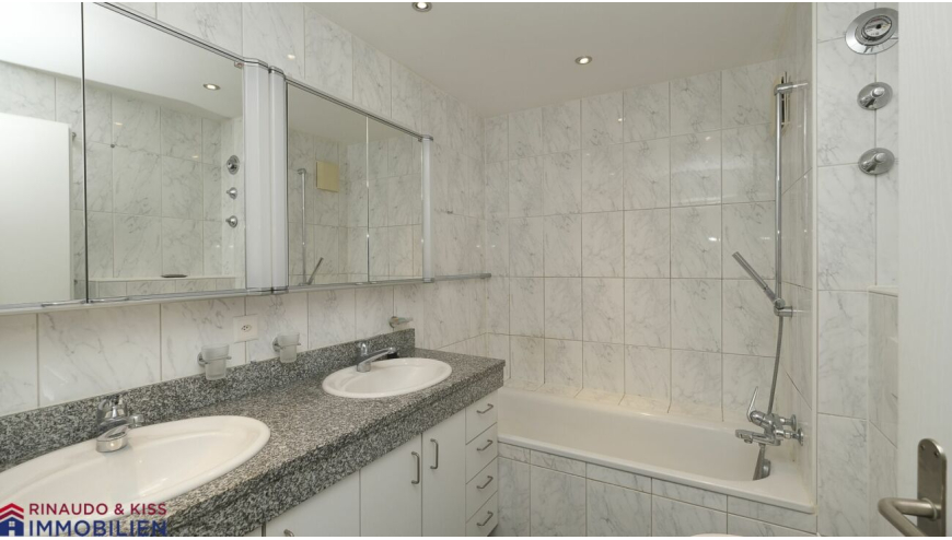 Helles Badezimmer mit Doppelwaschtisch und Wanne