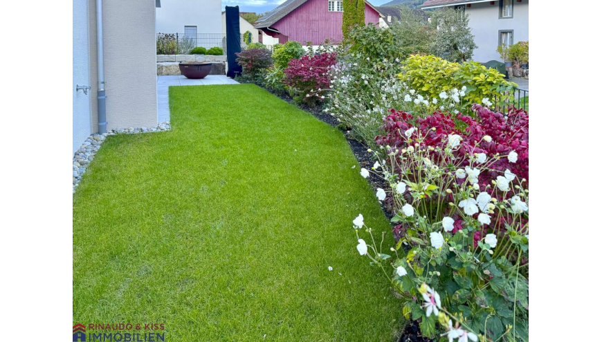 Gepflegter Garten mit blühenden Beeten