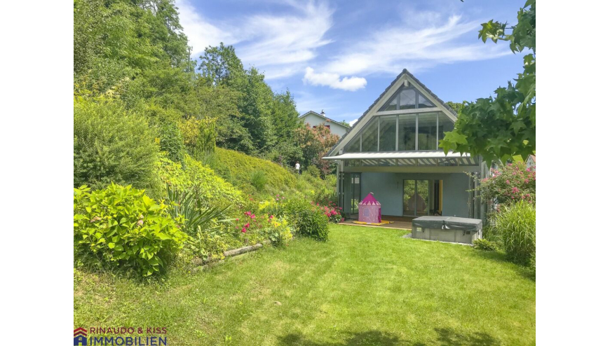 Gartenansicht eines Hauses mit großer Glasgiebel-Fassade