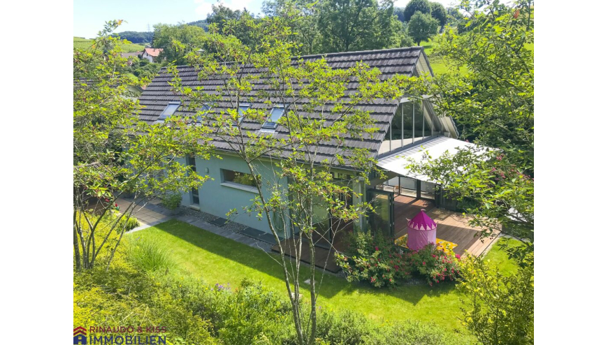 Gartenansicht eines Hauses mit Wintergarten