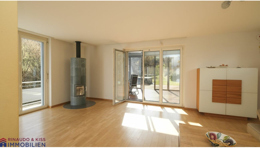 Heller Wohnraum mit Kaminofen und Terrassenzugang