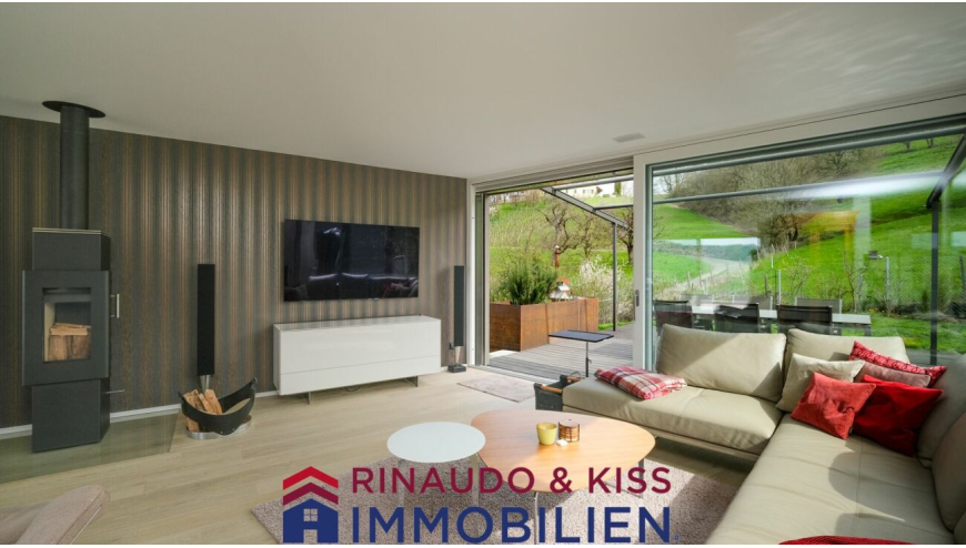 Moderner Wohnraum mit Glasfront und Blick ins Grüne